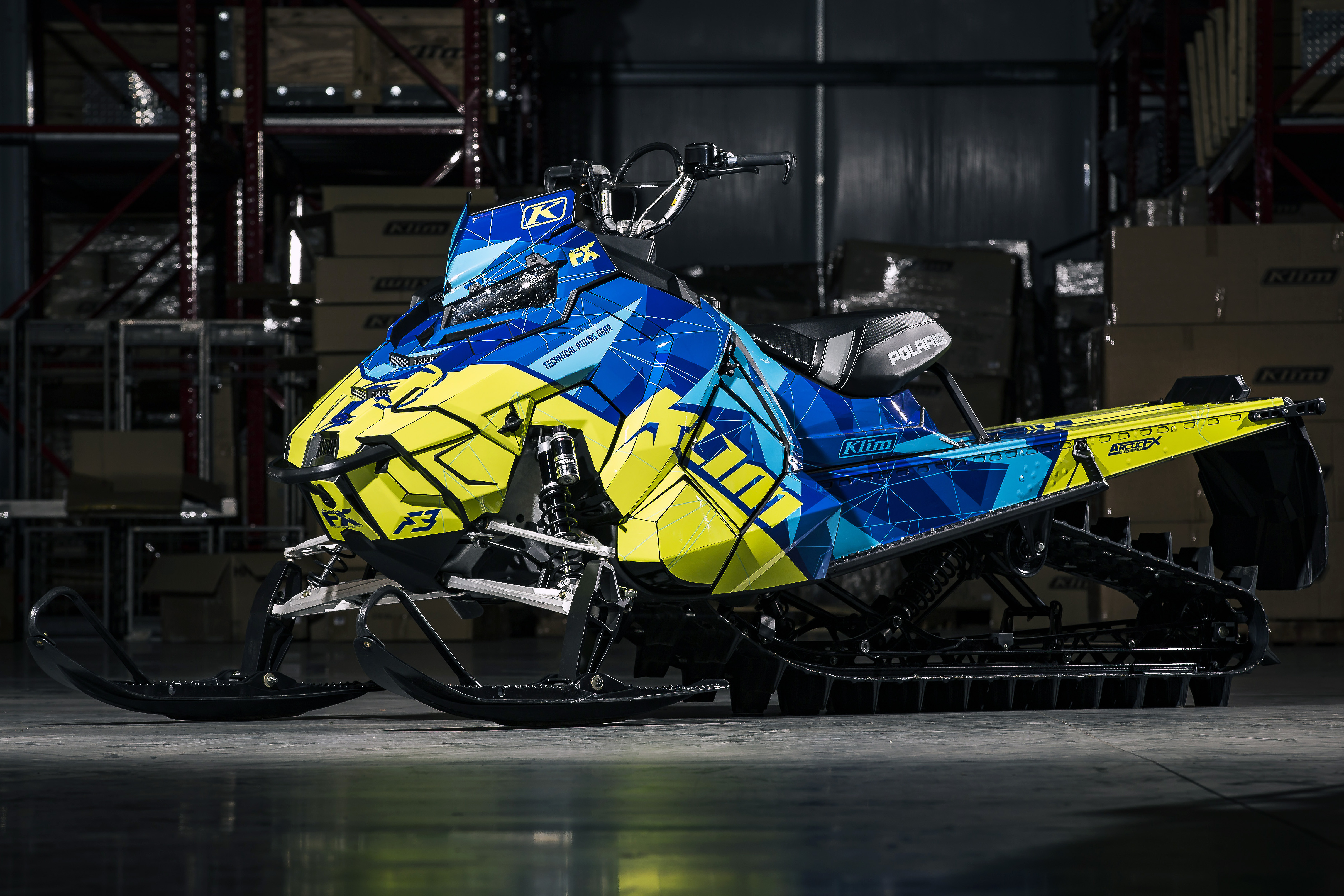 A Polaris Axys Mountain snowmobile with a blue and lime squeeze Klim F3 Camo custom vinyl wrap.