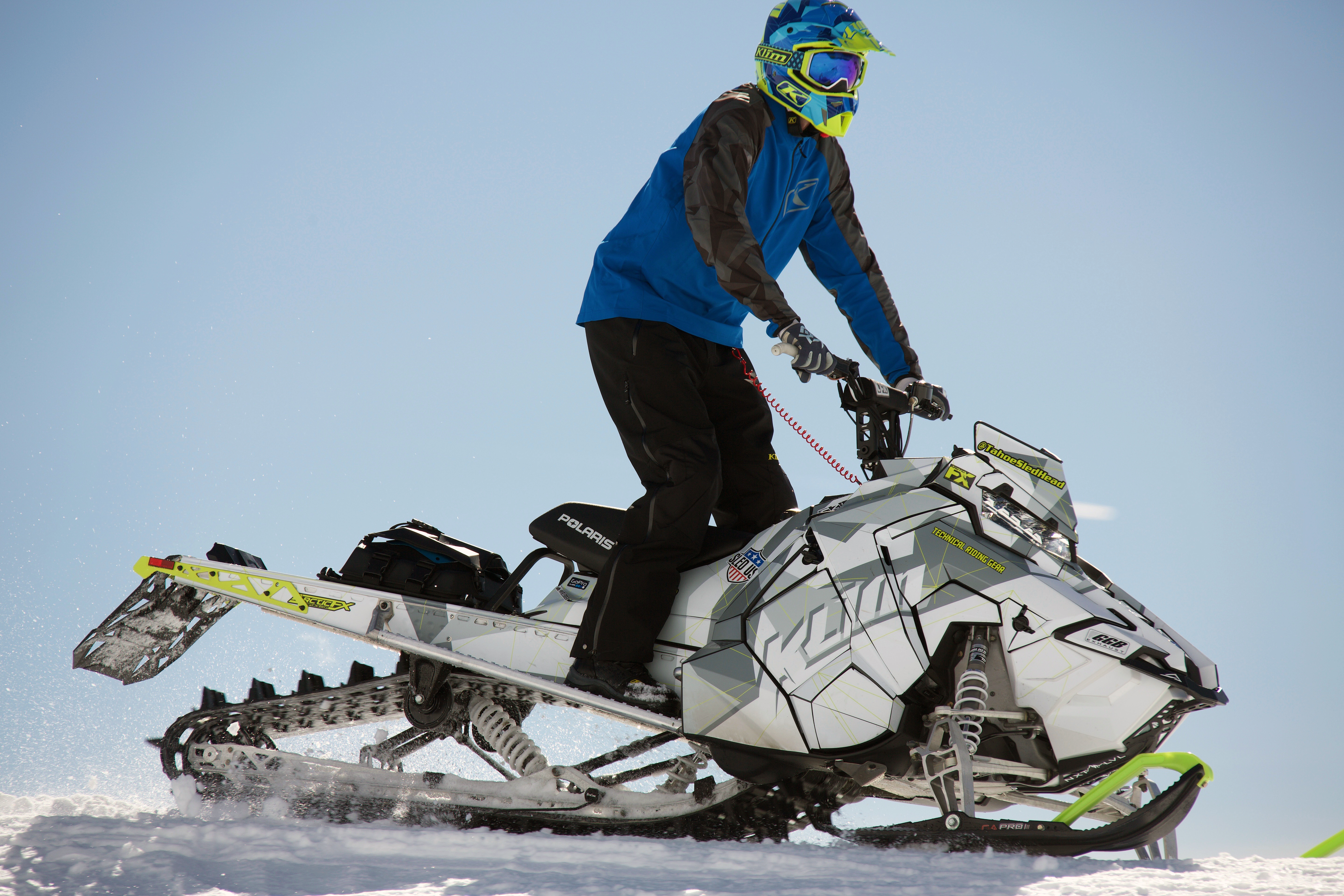 A Polaris Axys Mountain snowmobile with a white, gray, and lime squeeze Klim F3 Camo custom vinyl wrap.