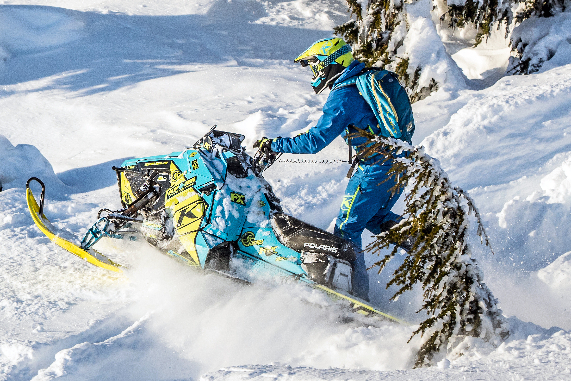 A Polaris Axys Mountain snowmobile with a black, blue, and lime squeeze Klim F5 Ion custom vinyl wrap.