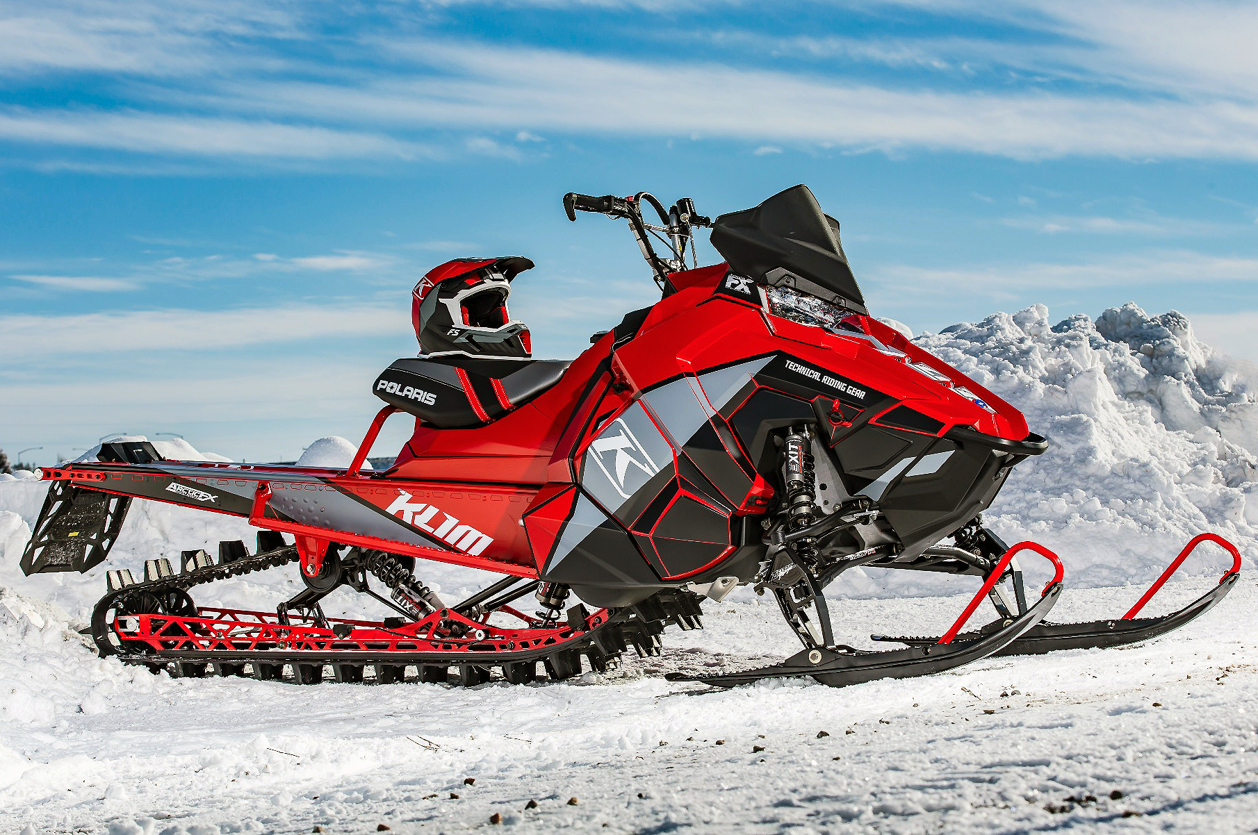 A Polaris Axys Mountain snowmobile with a black, red, and gray Klim F5 Ion custom vinyl wrap.