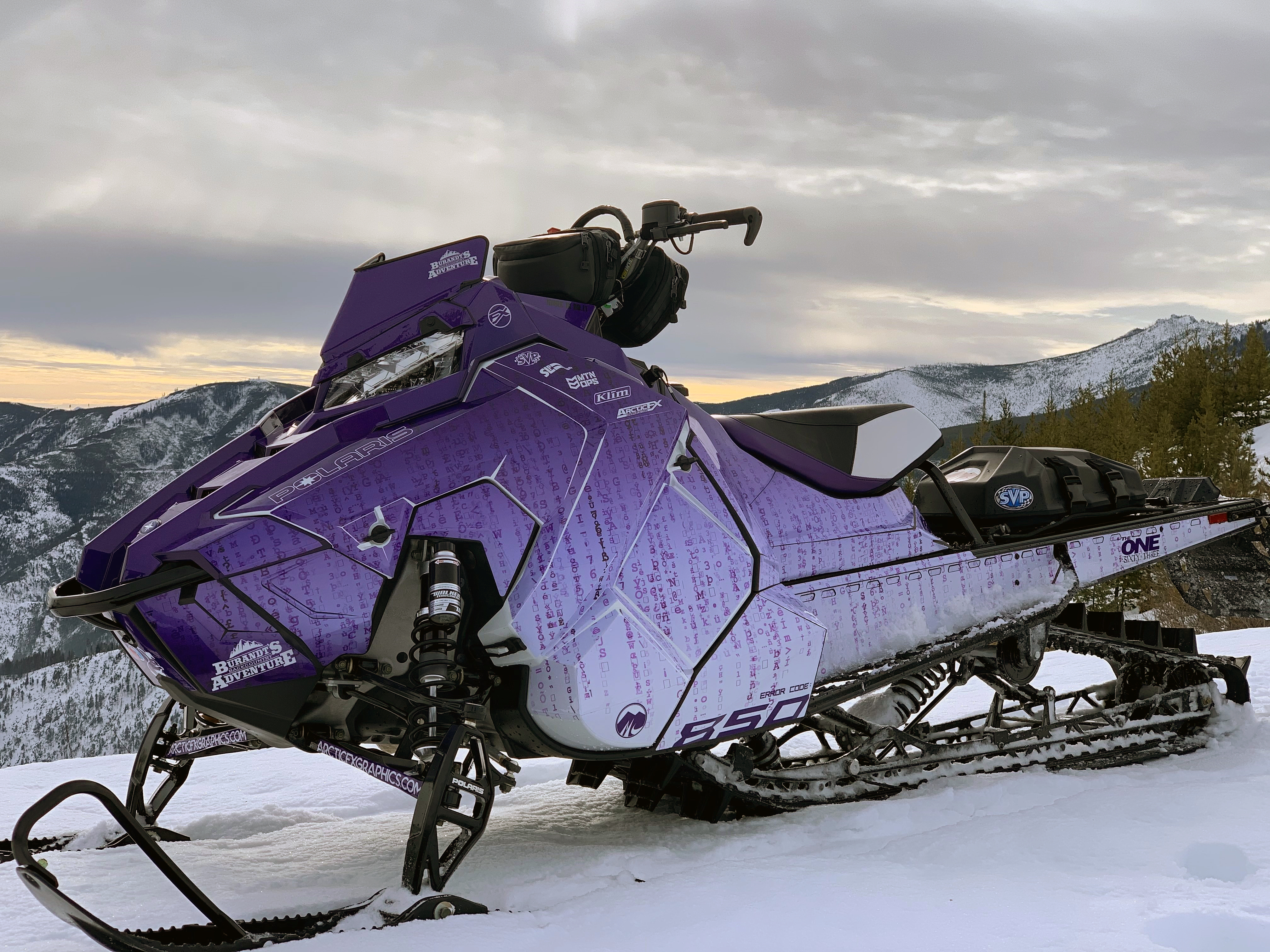 A Polaris Axys Mountain snowmobile with a purple and white Matrix Trinity movie custom vinyl wrap.