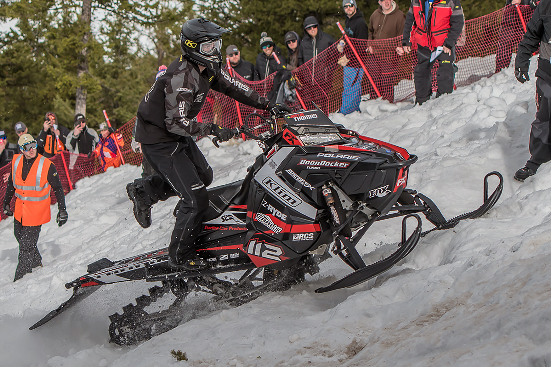 A Polaris Axys Mountain snowmobile with a black, red, and white Relay custom vinyl wrap.