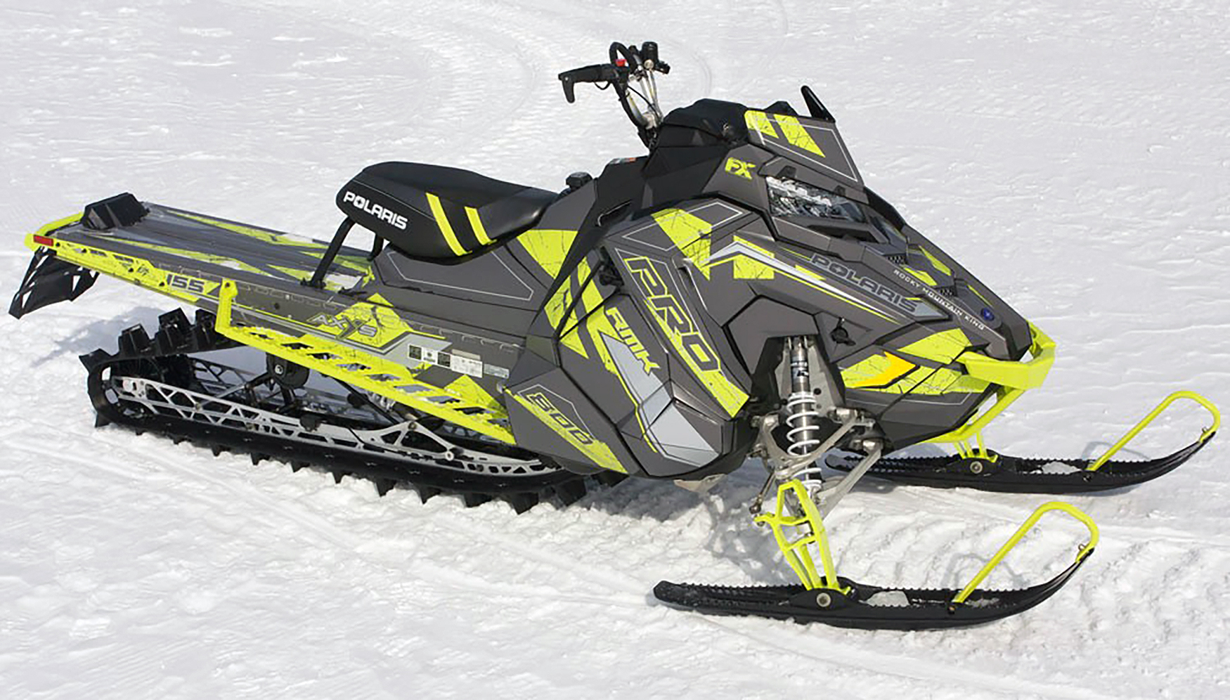 A Polaris Axys Mountain snowmobile with a lime squeeze and gray Rogue custom vinyl wrap.