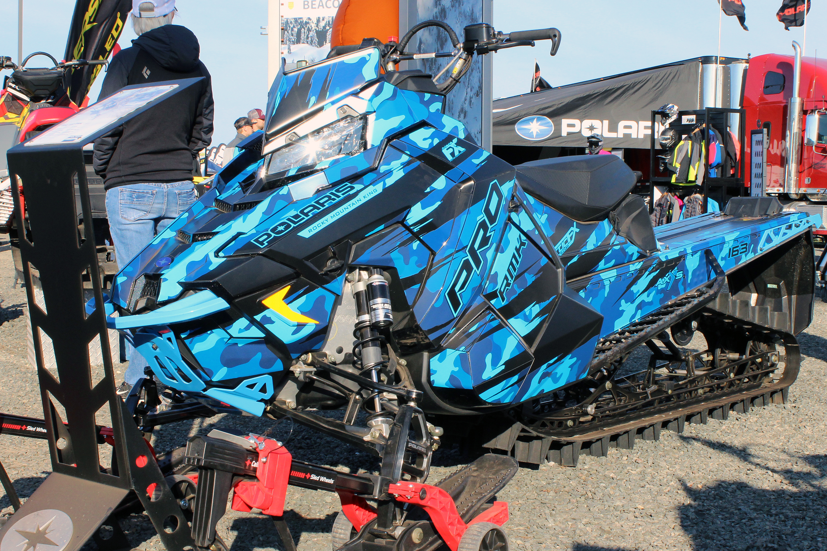 A Polaris Axys Mountain snowmobile with a blue, and black, RR Camo custom vinyl wrap.