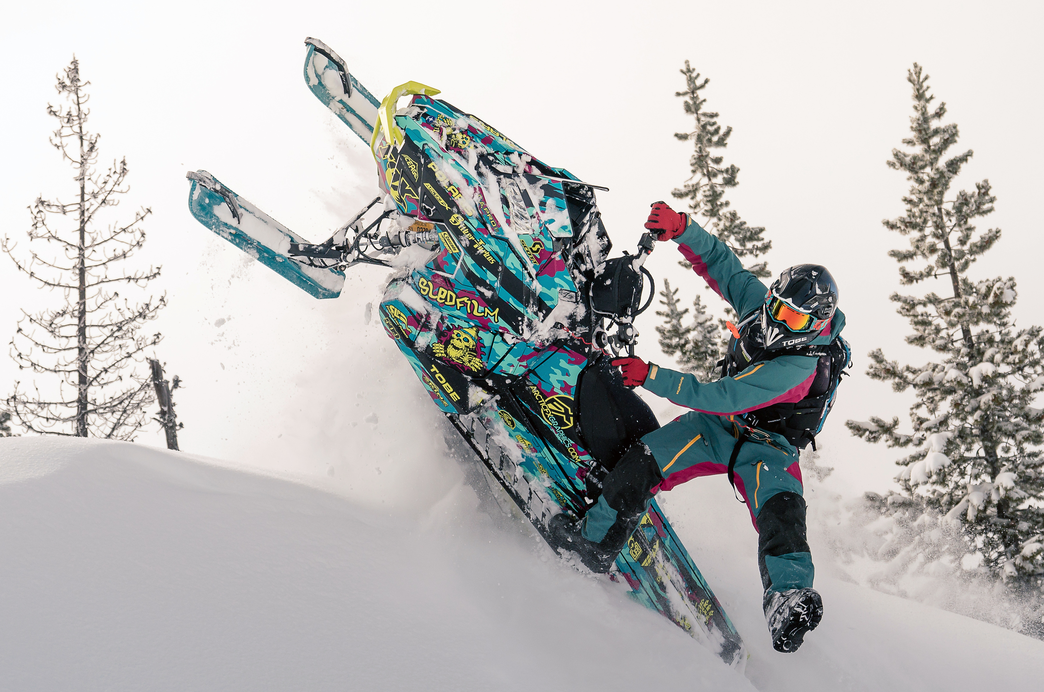 A Polaris Axys Mountain snowmobile with a lime squeeze, blue, and pink RR Camo custom vinyl wrap.