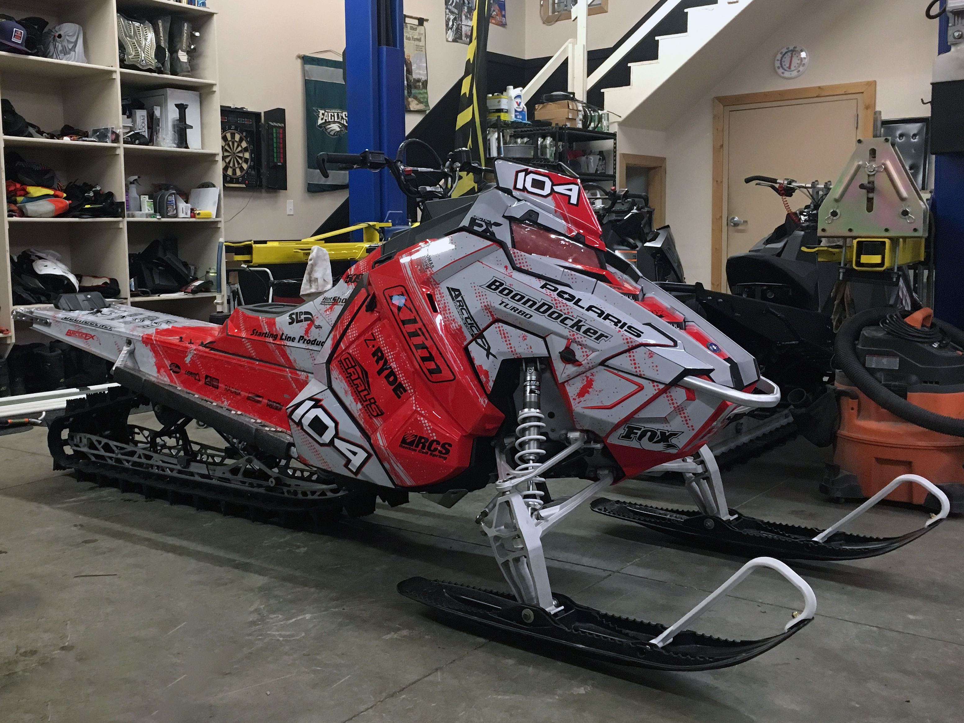 A Polaris Axys Mountain snowmobile with a red and gray Sabotage custom vinyl wrap.