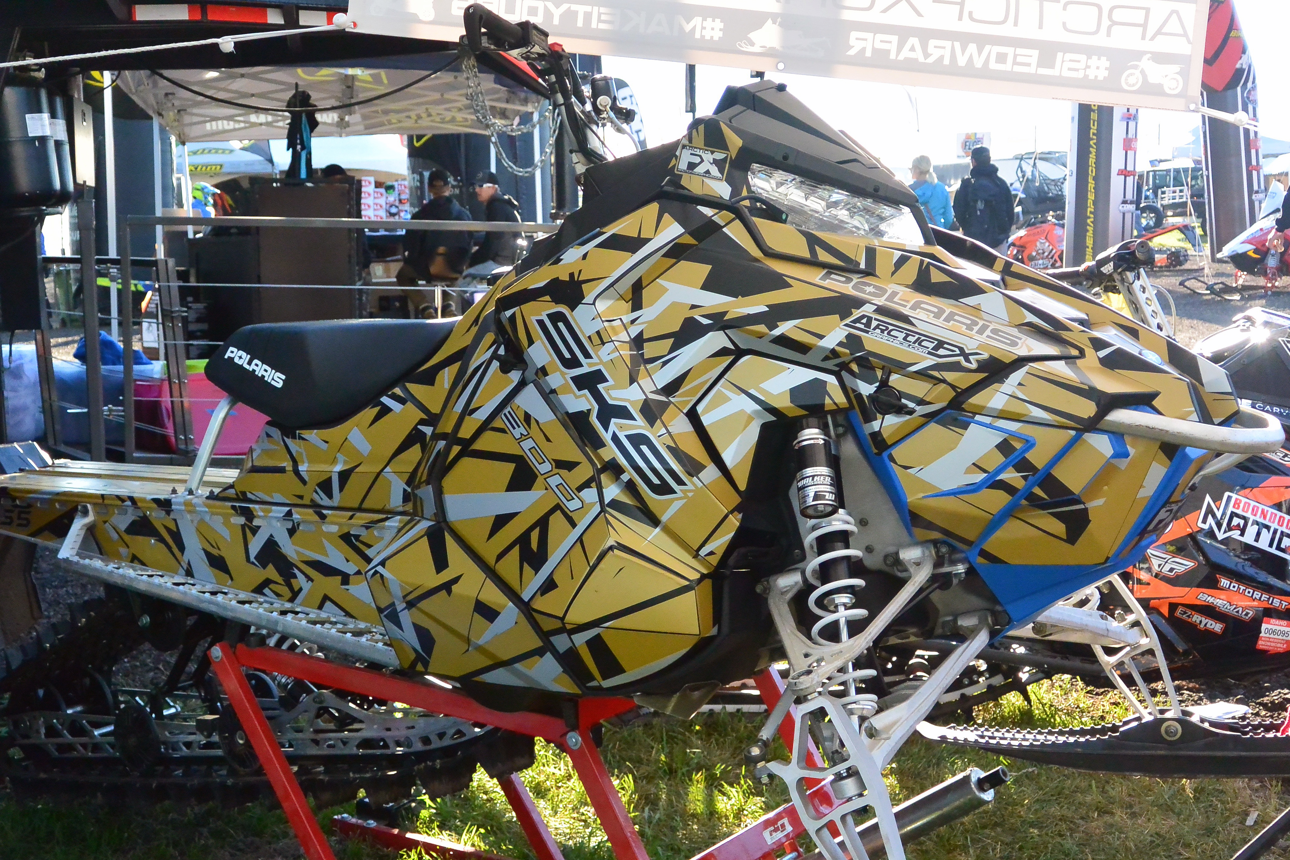 A Polaris Axys Mountain snowmobile with a white, black and gold Shattered Illusion custom vinyl wrap.