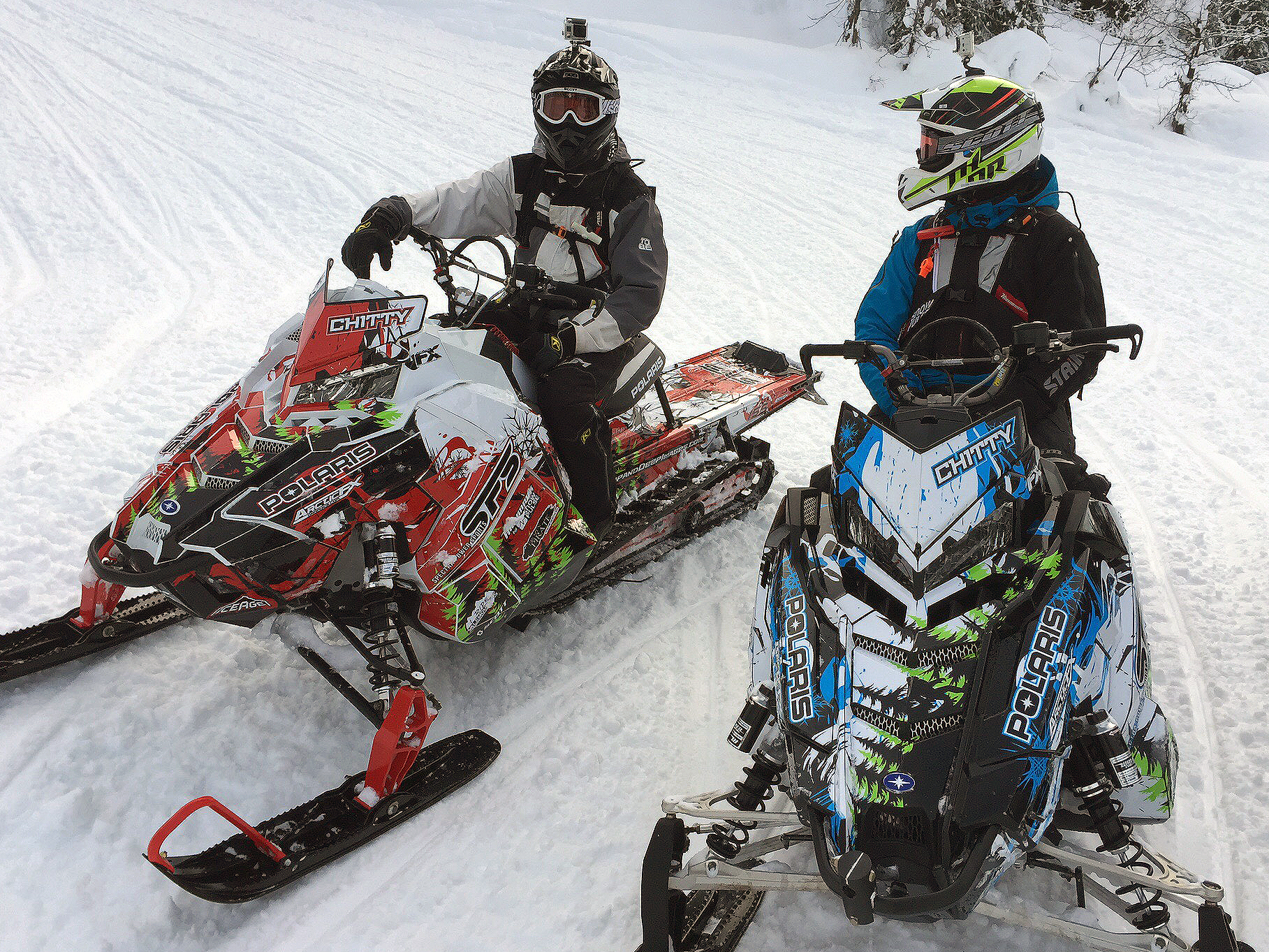 A Polaris Axys Mountain snowmobile with a lime, white, and blue Sub Zero custom vinyl wrap.