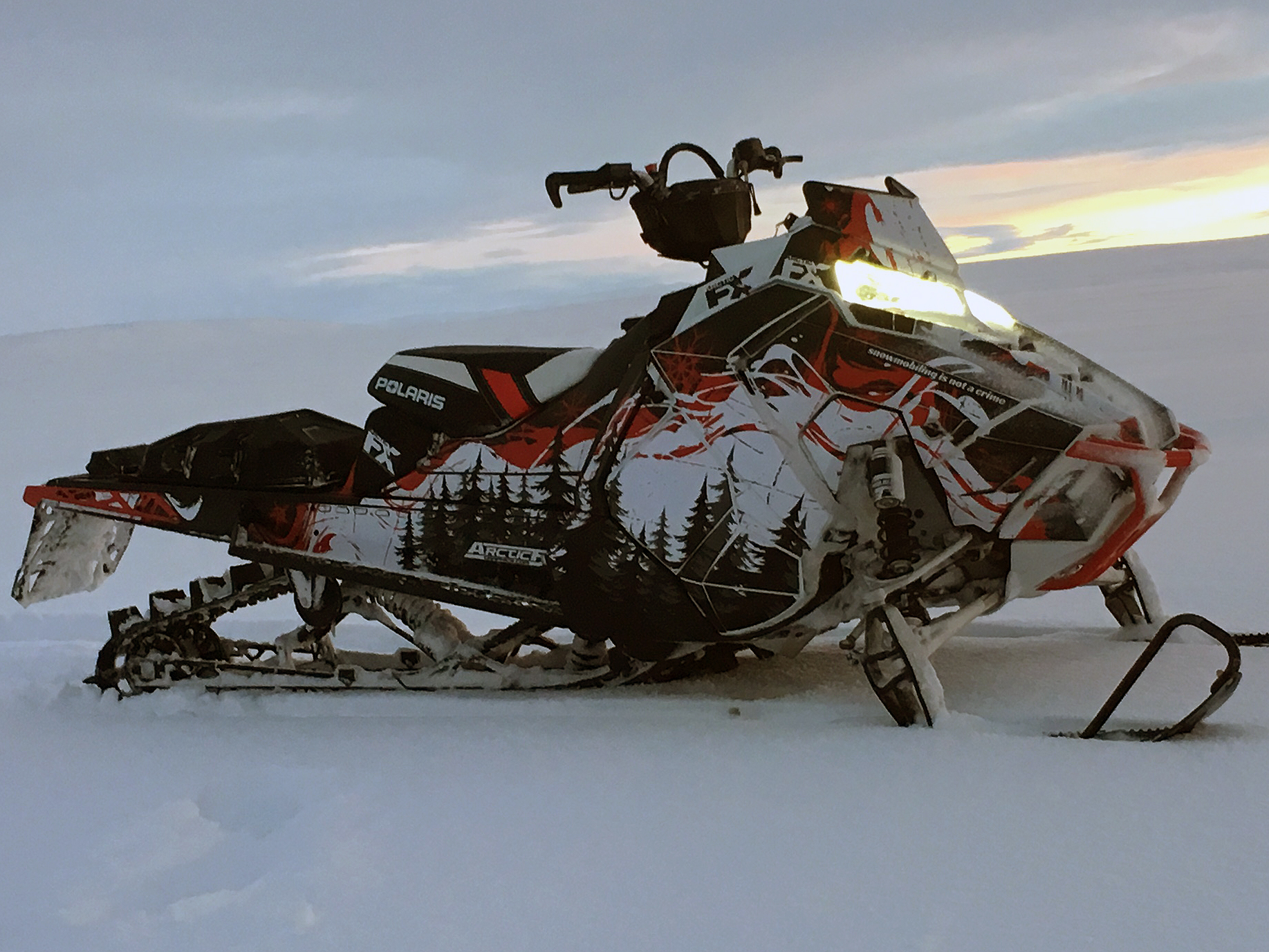 A Polaris Axys Mountain snowmobile with a red, white, and black Sub Zero custom vinyl wrap.