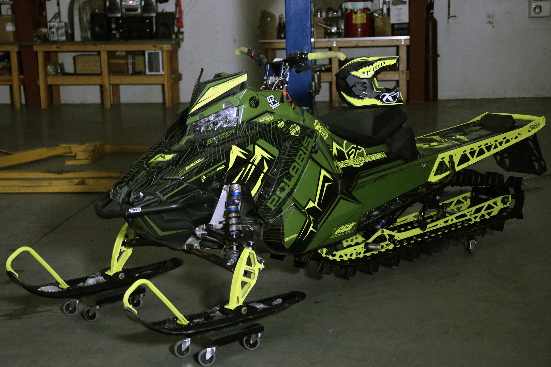 A Polaris Axys Mountain snowmobile with a lime squeeze, army green, and black Teton custom vinyl wrap.