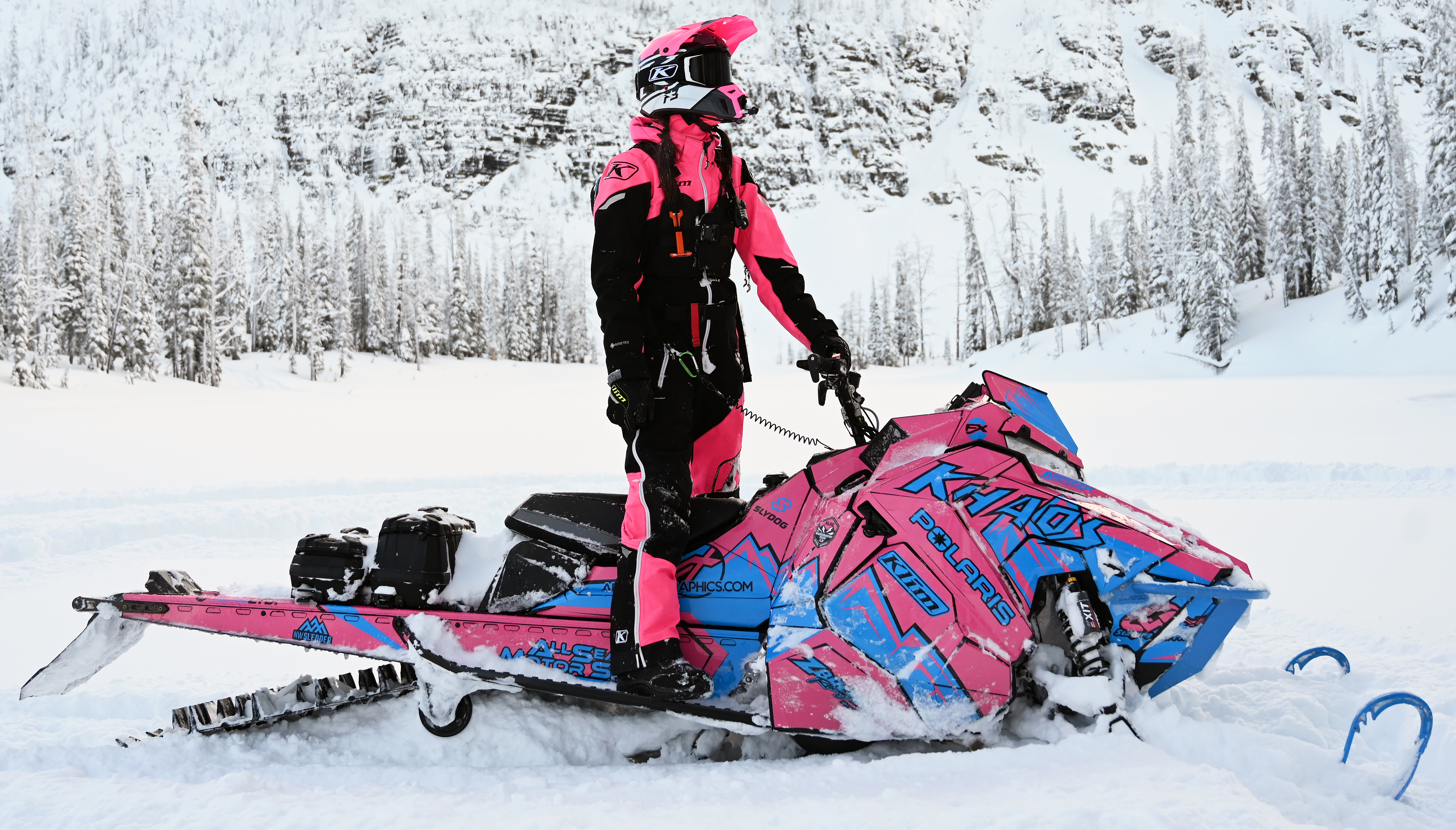 A Polaris Axys Mountain snowmobile with a pink and blue Teton custom vinyl wrap.