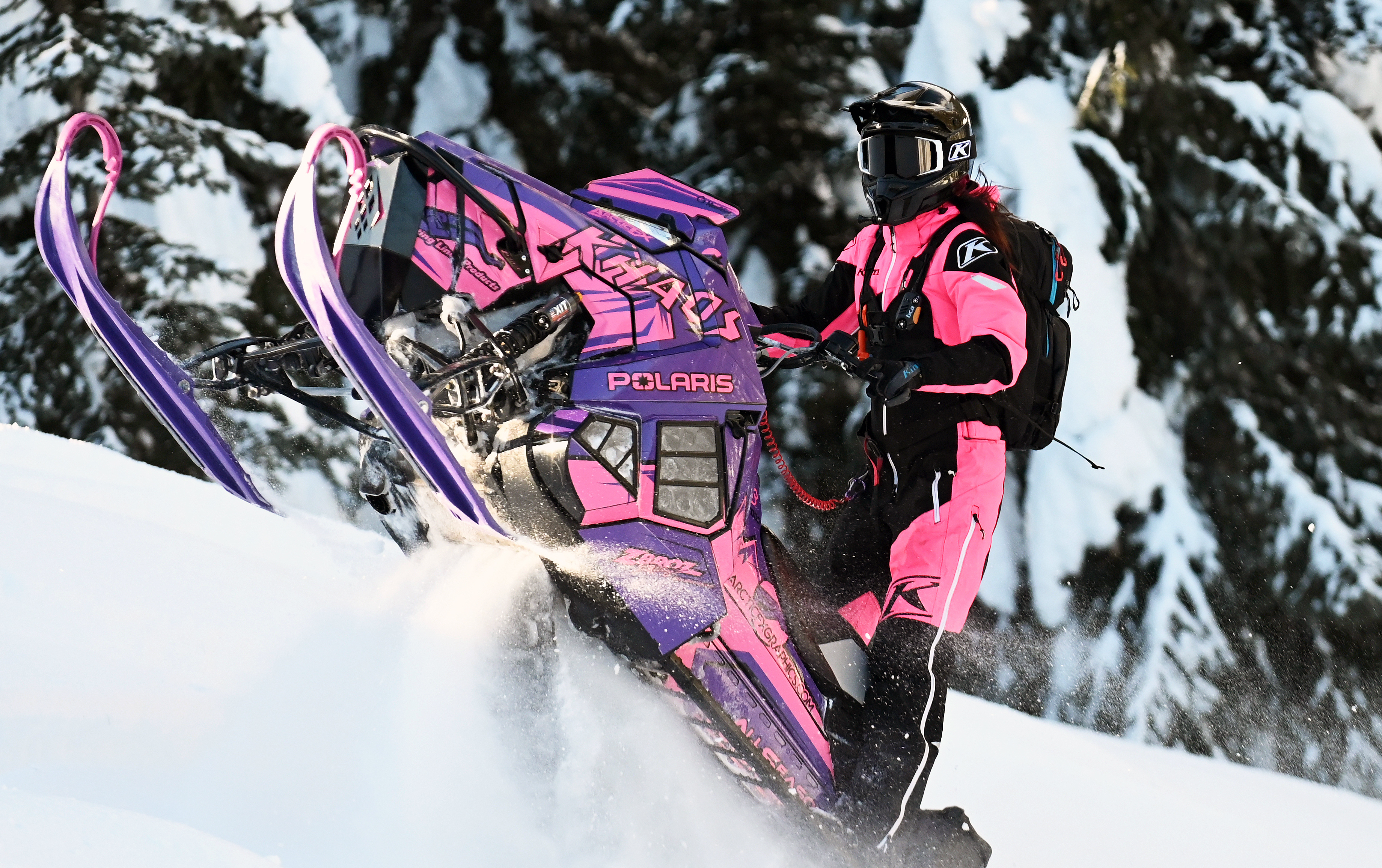 A Polaris Axys Mountain snowmobile with a pink and purple Teton custom vinyl wrap.