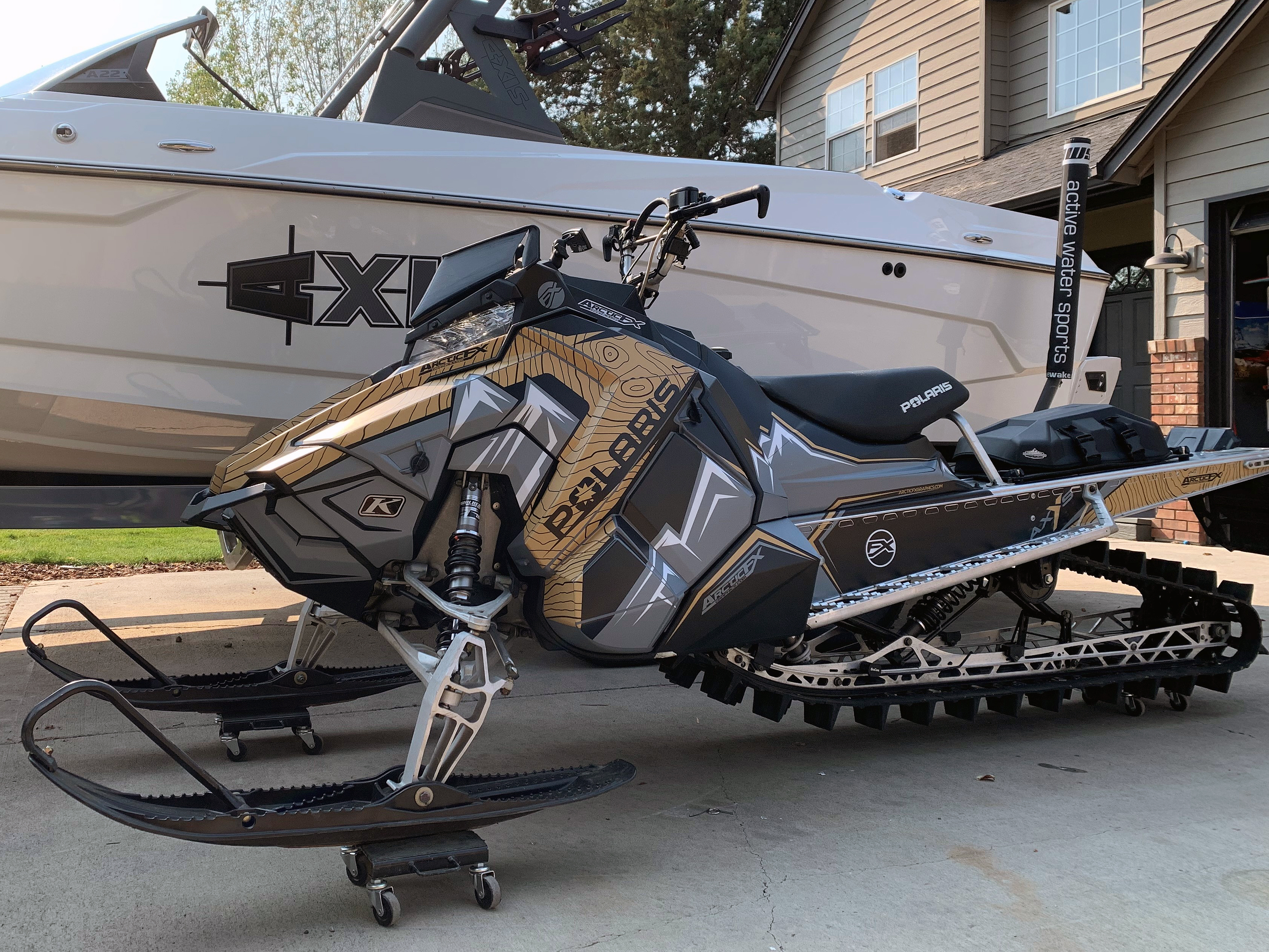 A Polaris Axys Mountain snowmobile with a tan, white, and black Teton custom vinyl wrap.