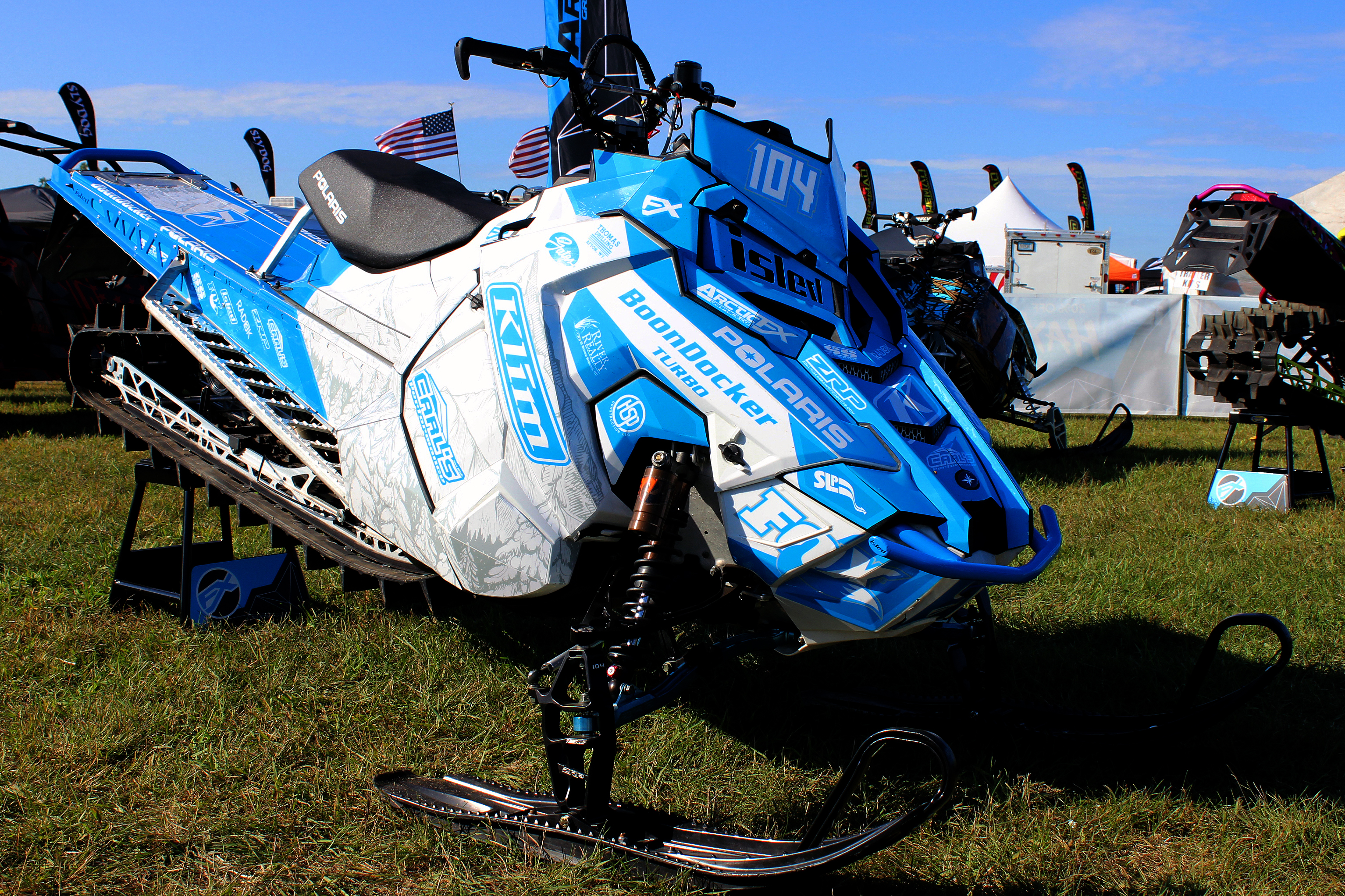 A Polaris Axys Mountain snowmobile with a blue and white Andy Thomas Peaked custom vinyl wrap.