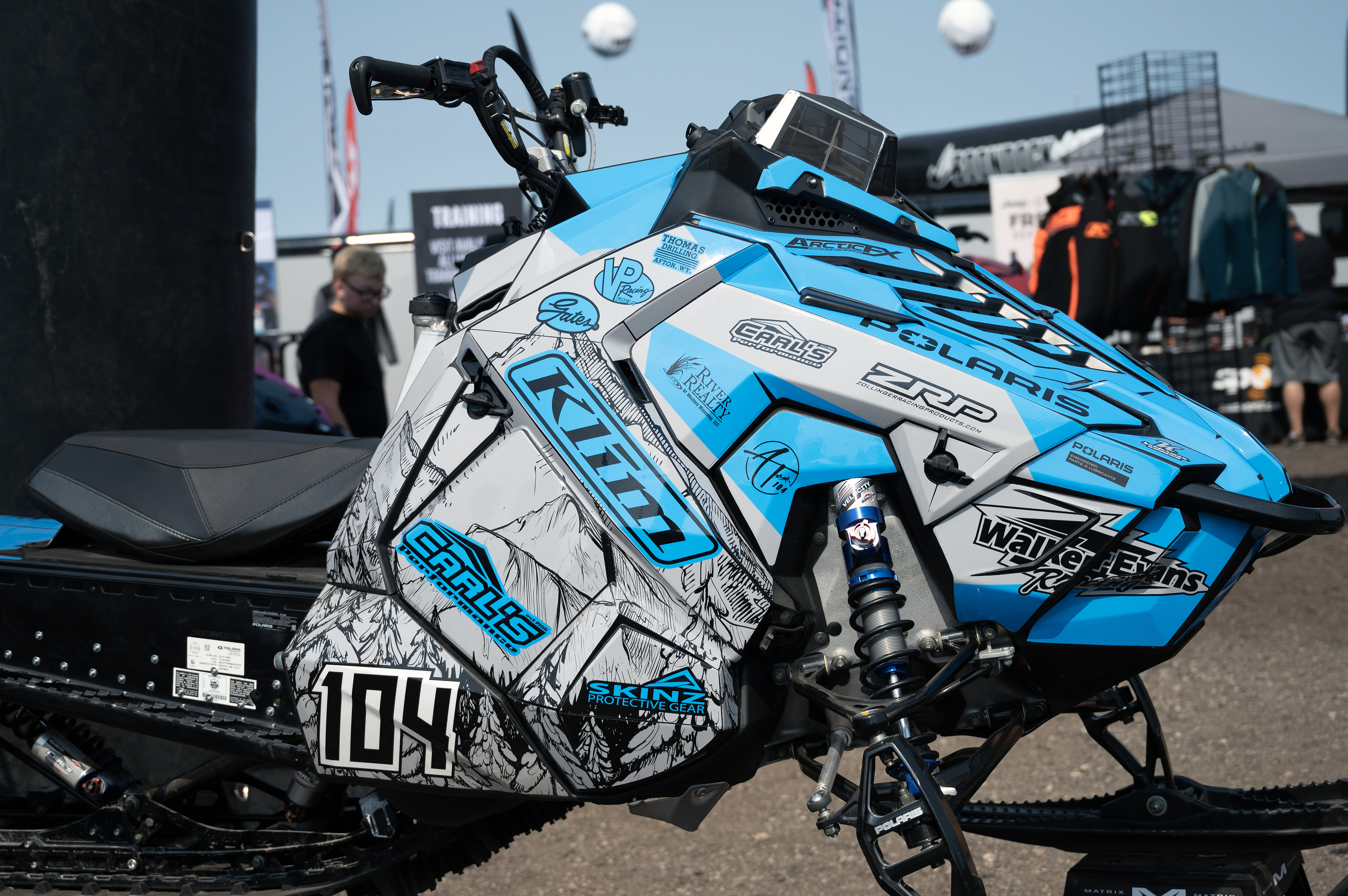 A Polaris Axys Mountain snowmobile with a blue, gray, and black Andy Thomas Peaked custom vinyl wrap.