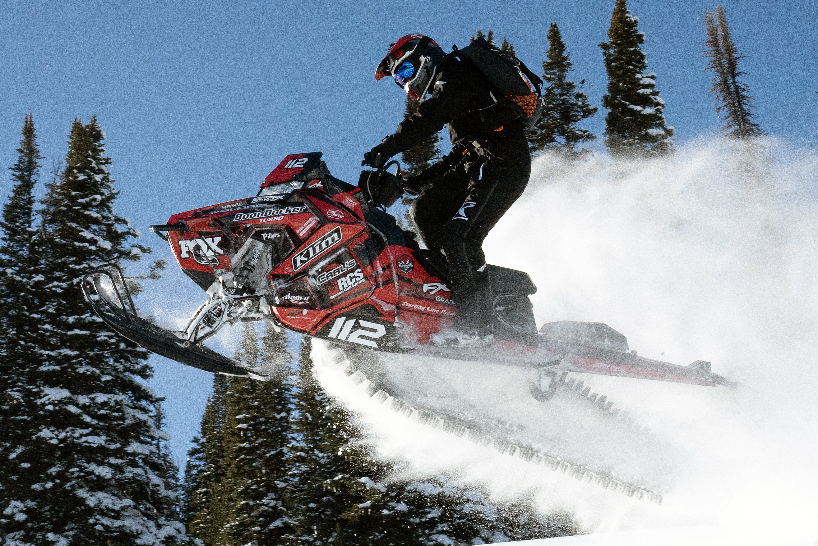 A Polaris Axys Mountain snowmobile with a red and black Justin Thomas Velocity custom vinyl wrap.