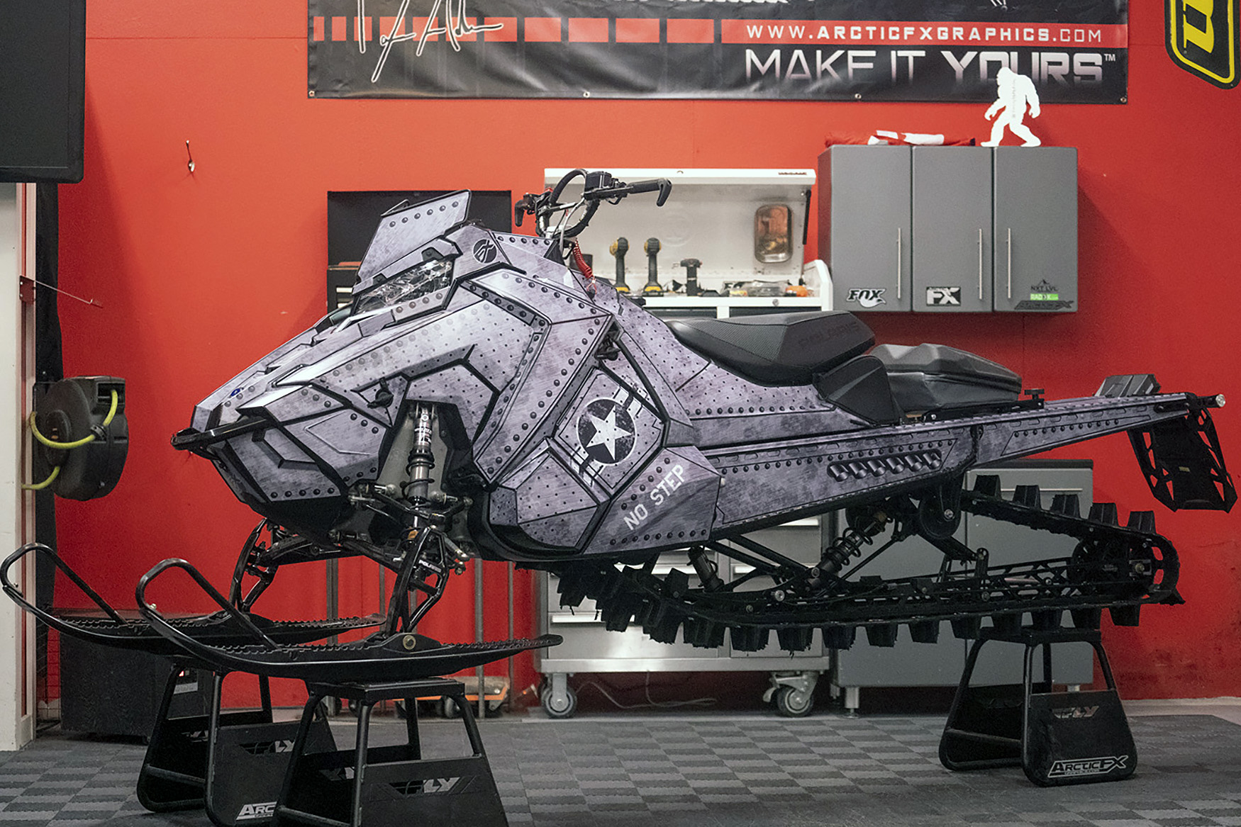A Polaris Axys Mountain snowmobile with a gray photo realistic fighter plane Warhawk custom vinyl wrap.