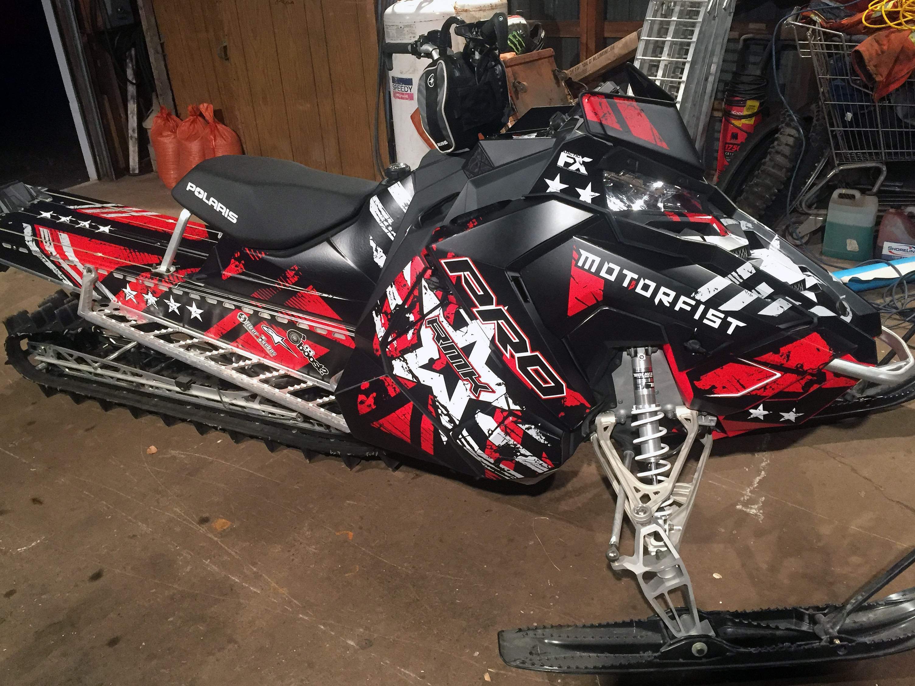 A Polaris Axys Mountain snowmobile with a red, black, and white Wartorn custom vinyl wrap.