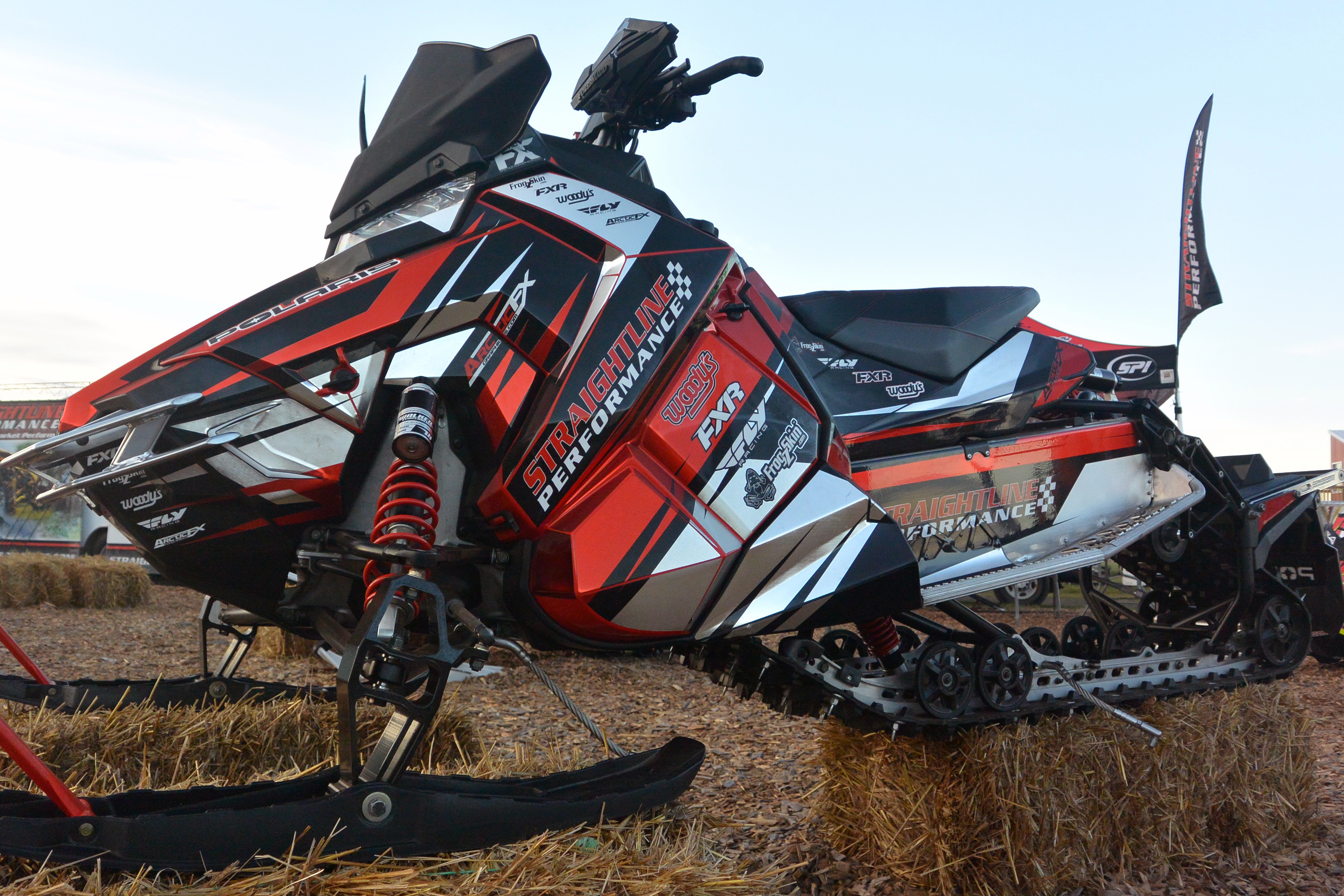 A Polaris Axys Trail snowmobile with a black, chrome, and red Straightline custom vinyl wrap.