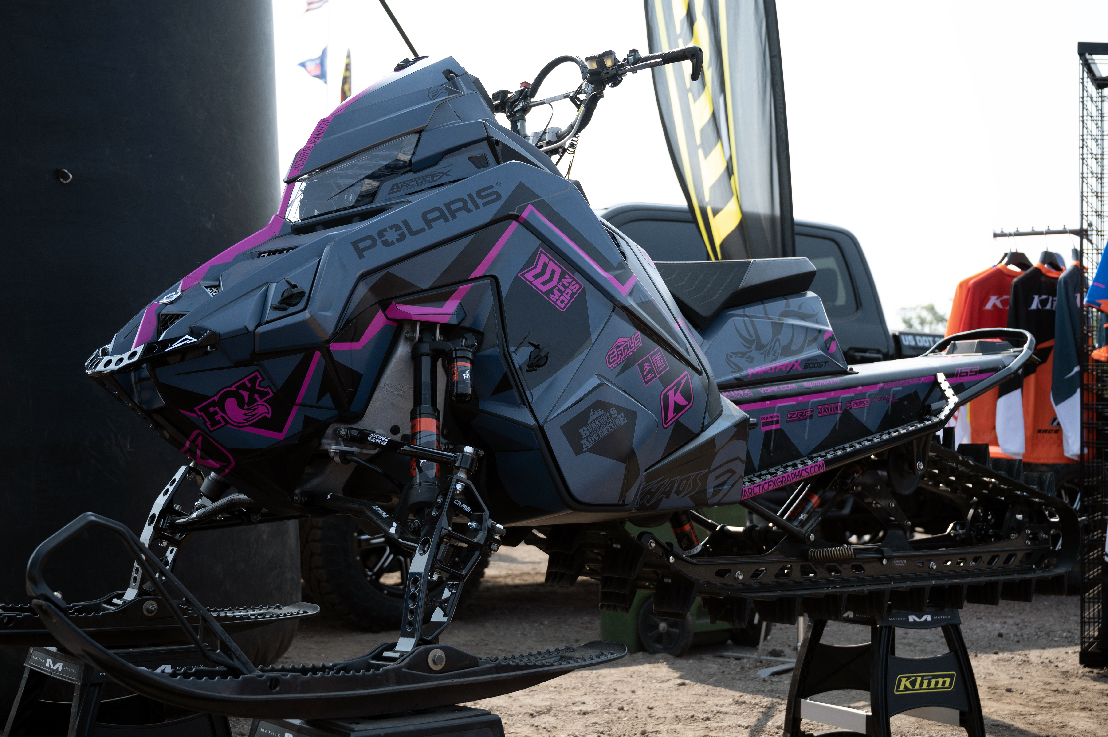 A Polaris Matryx Mountain snowmobile with a pink, black, and gray Burandt Incognito custom vinyl wrap.