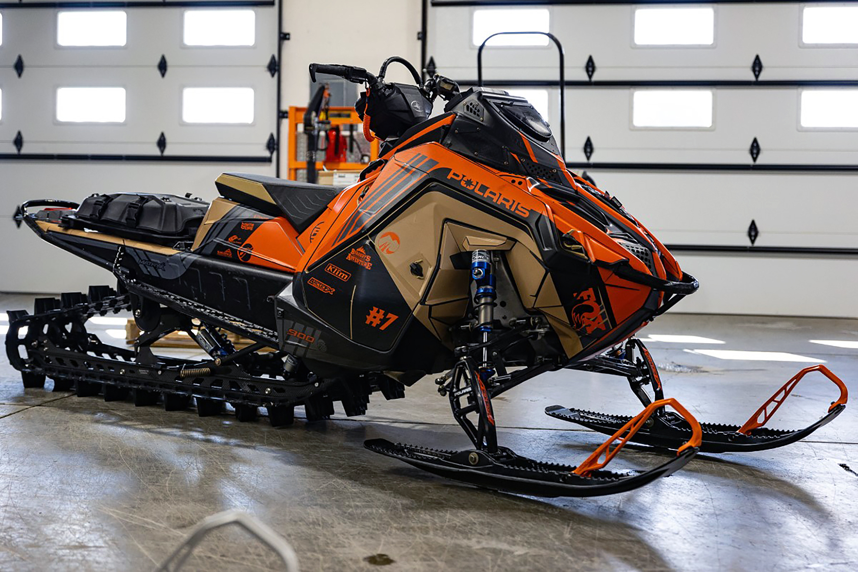 A Polaris Matryx Mountain snowmobile with a tan, orange, and black Cobra MC custom vinyl wrap.