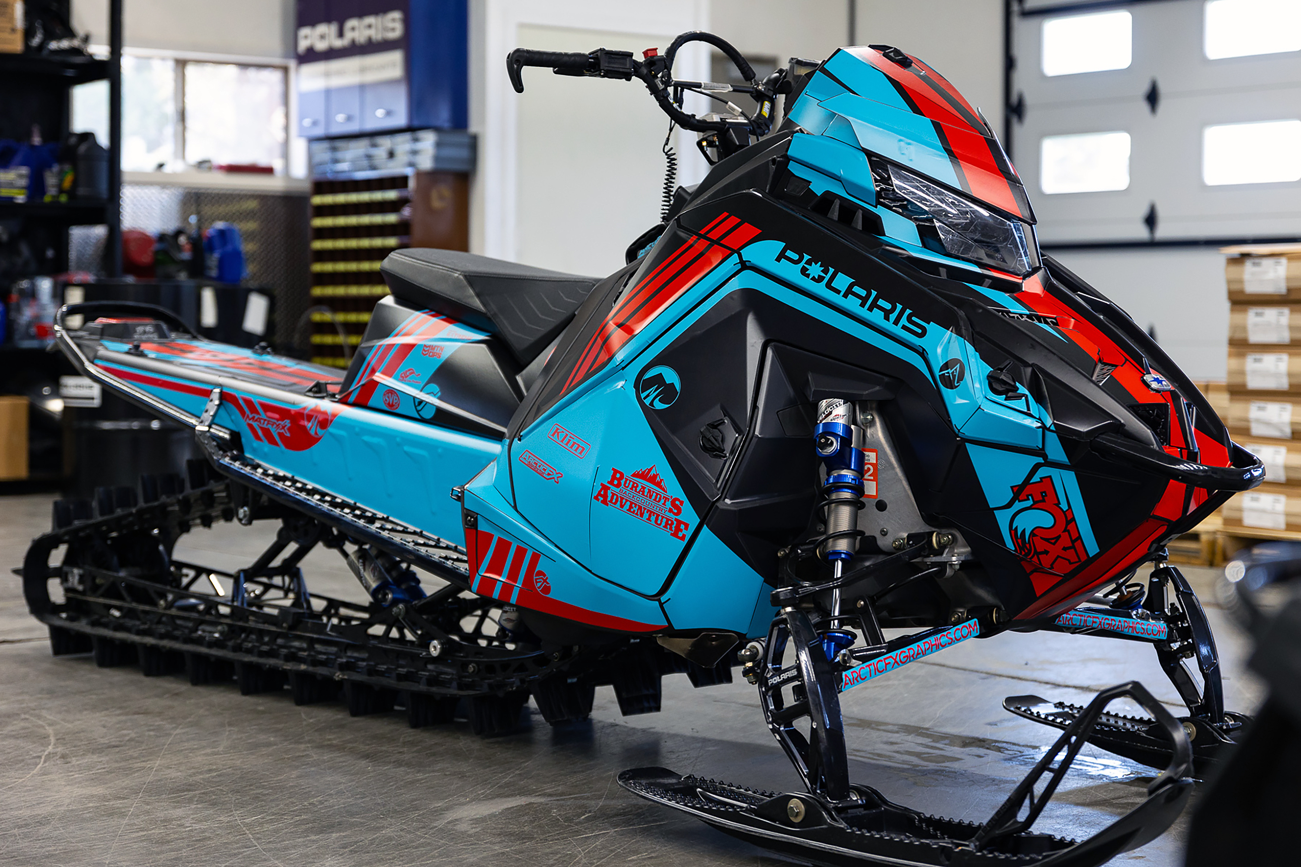 A Polaris Matryx Mountain snowmobile with a red, blue, and black Cobra MC custom vinyl wrap.