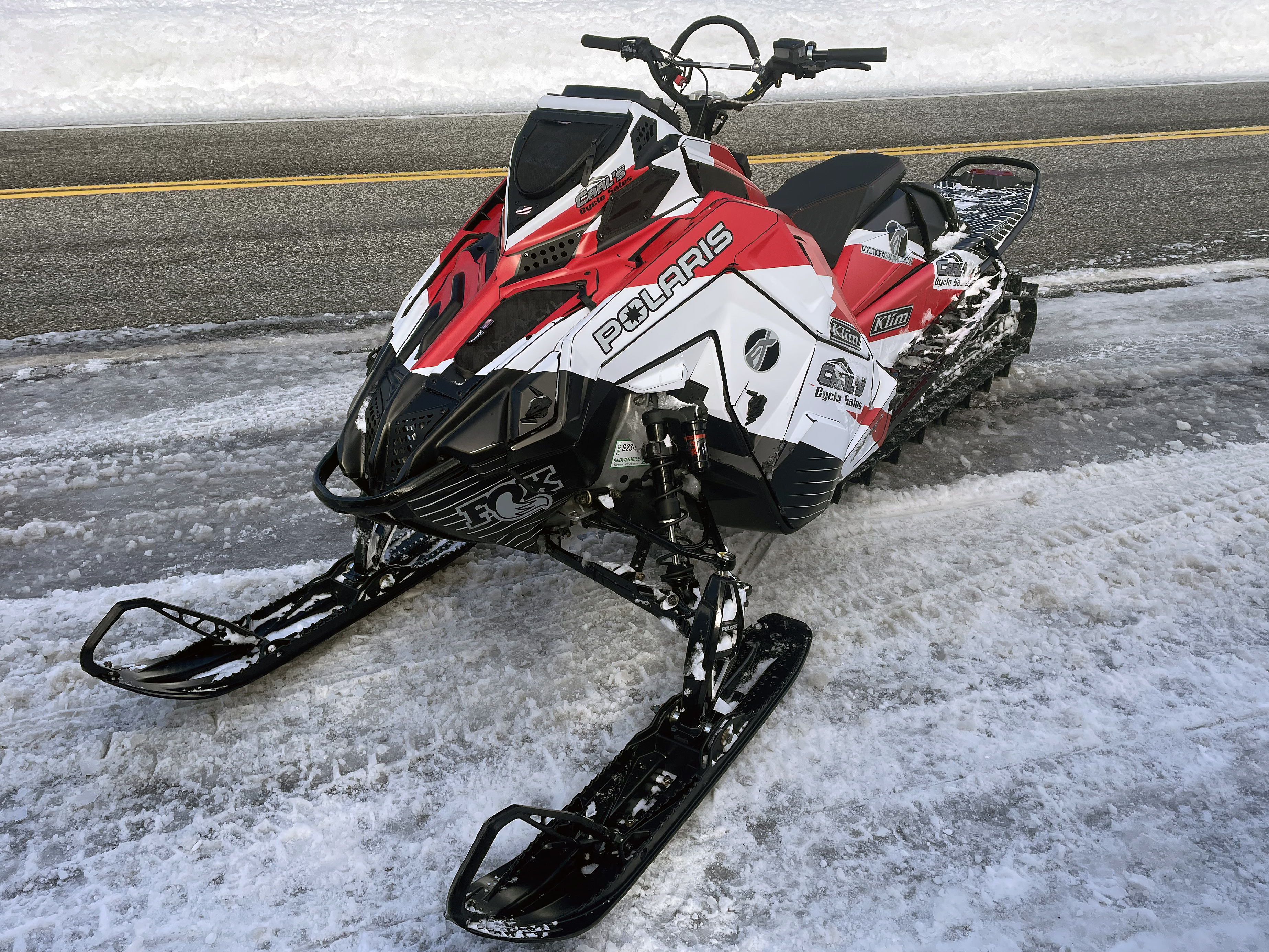 A Polaris Matryx Mountain snowmobile with a red and black Curtis Ascent custom vinyl wrap.