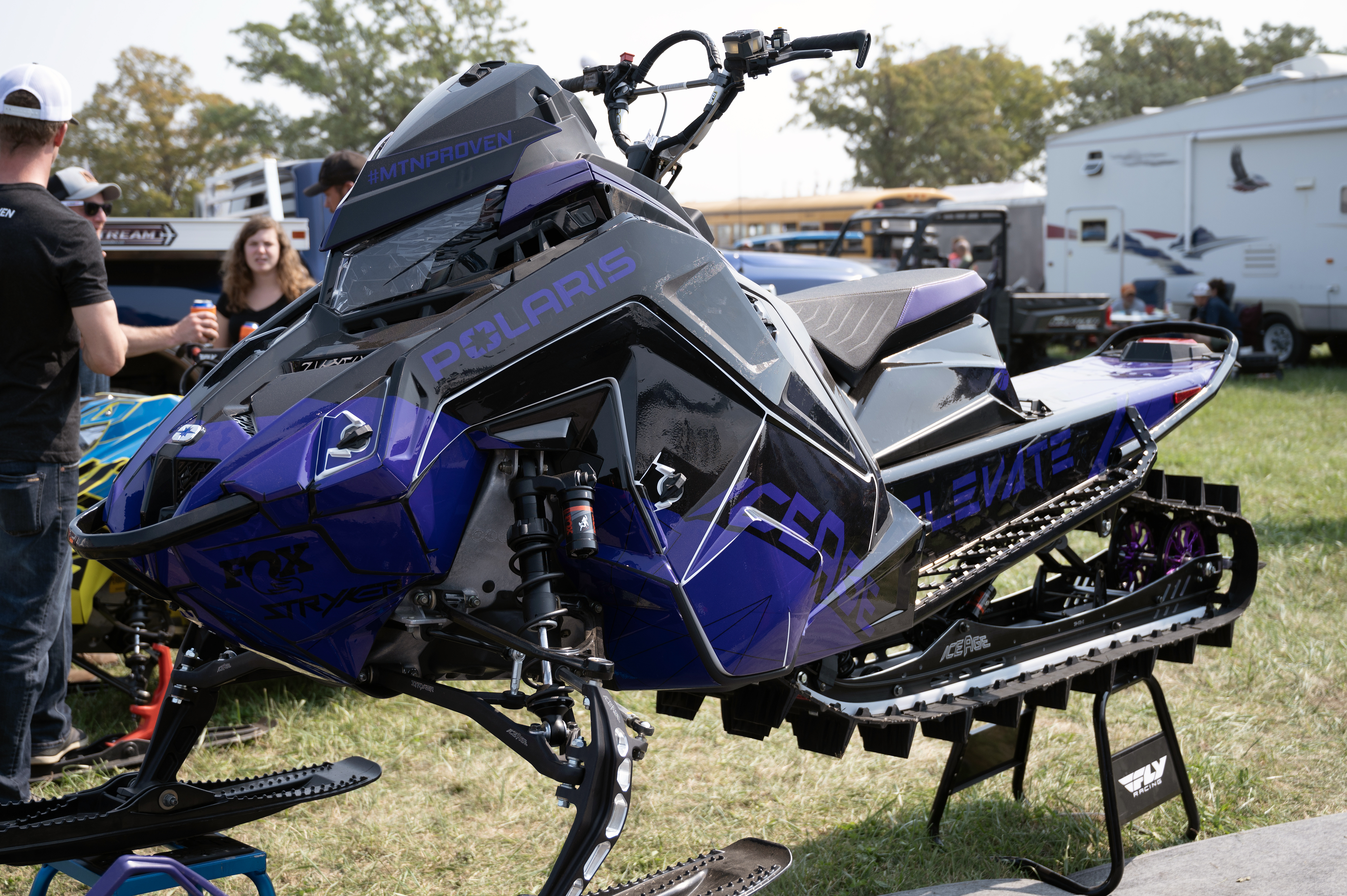 A Polaris Matryx Mountain snowmobile with a purple and black Klim F5 Ion custom vinyl wrap.