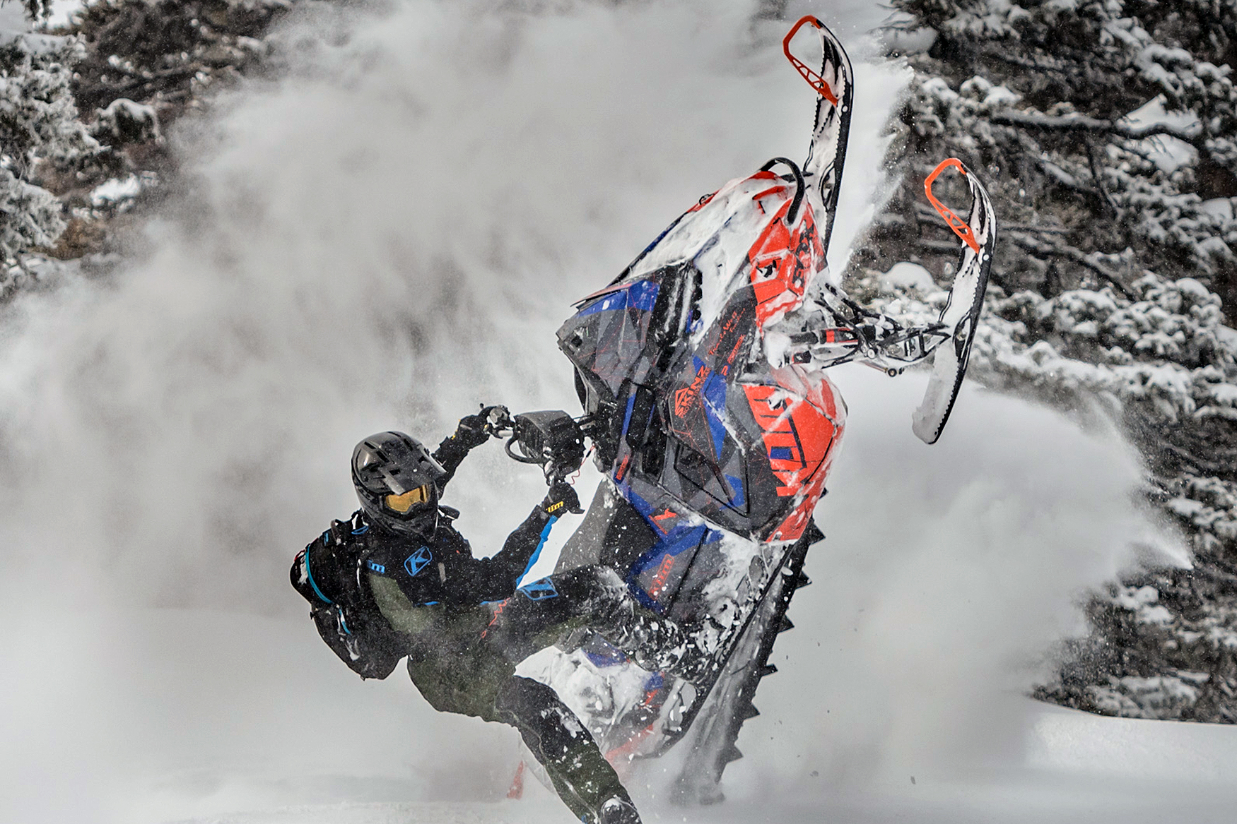 A Polaris Matryx Mountain snowmobile with a orange, blue and black Klim F3 camo custom vinyl wrap.