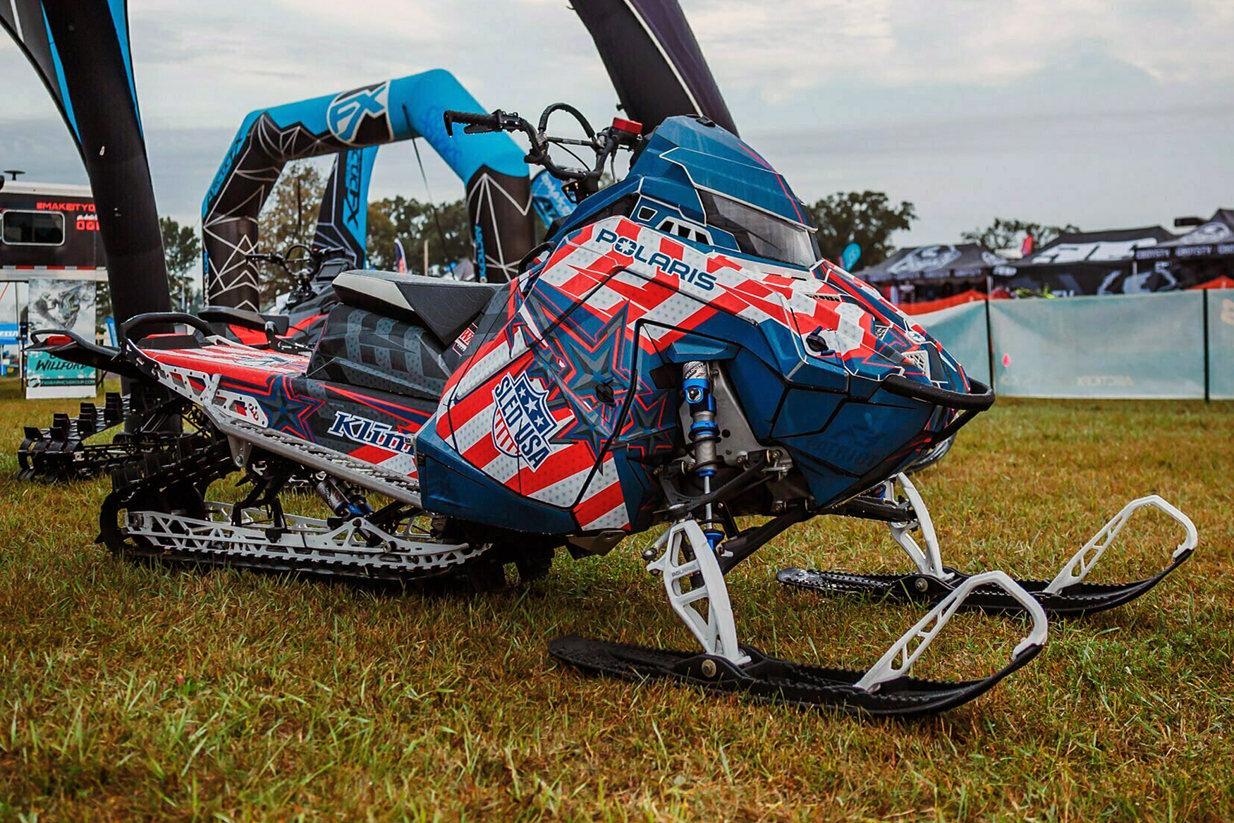 A Polaris Matryx Mountain snowmobile with a red white and blue Klim We The People custom vinyl wrap.