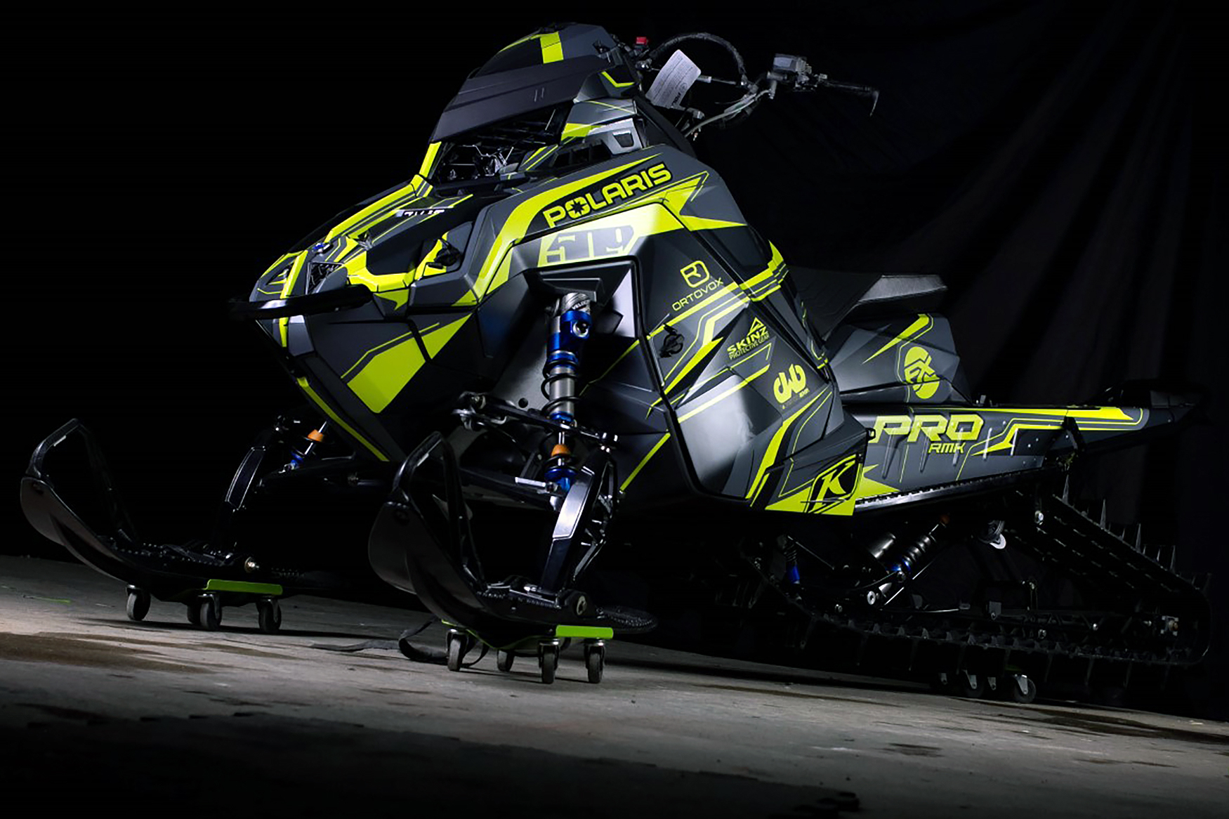 A Polaris Matryx Mountain snowmobile with a black, gray, and lime squeeze Sled USA Inertia custom vinyl wrap.