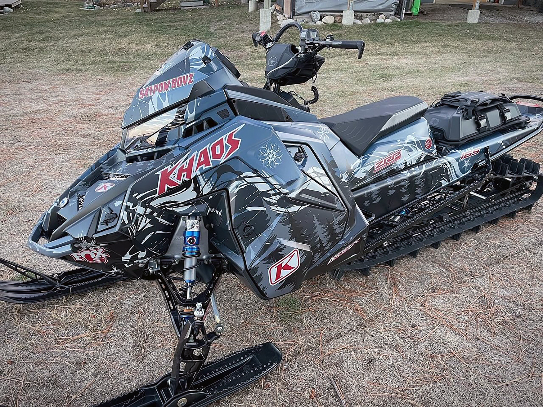 A Polaris Matryx Mountain snowmobile with a black, red, gray, and white Sub Zero custom vinyl wrap.