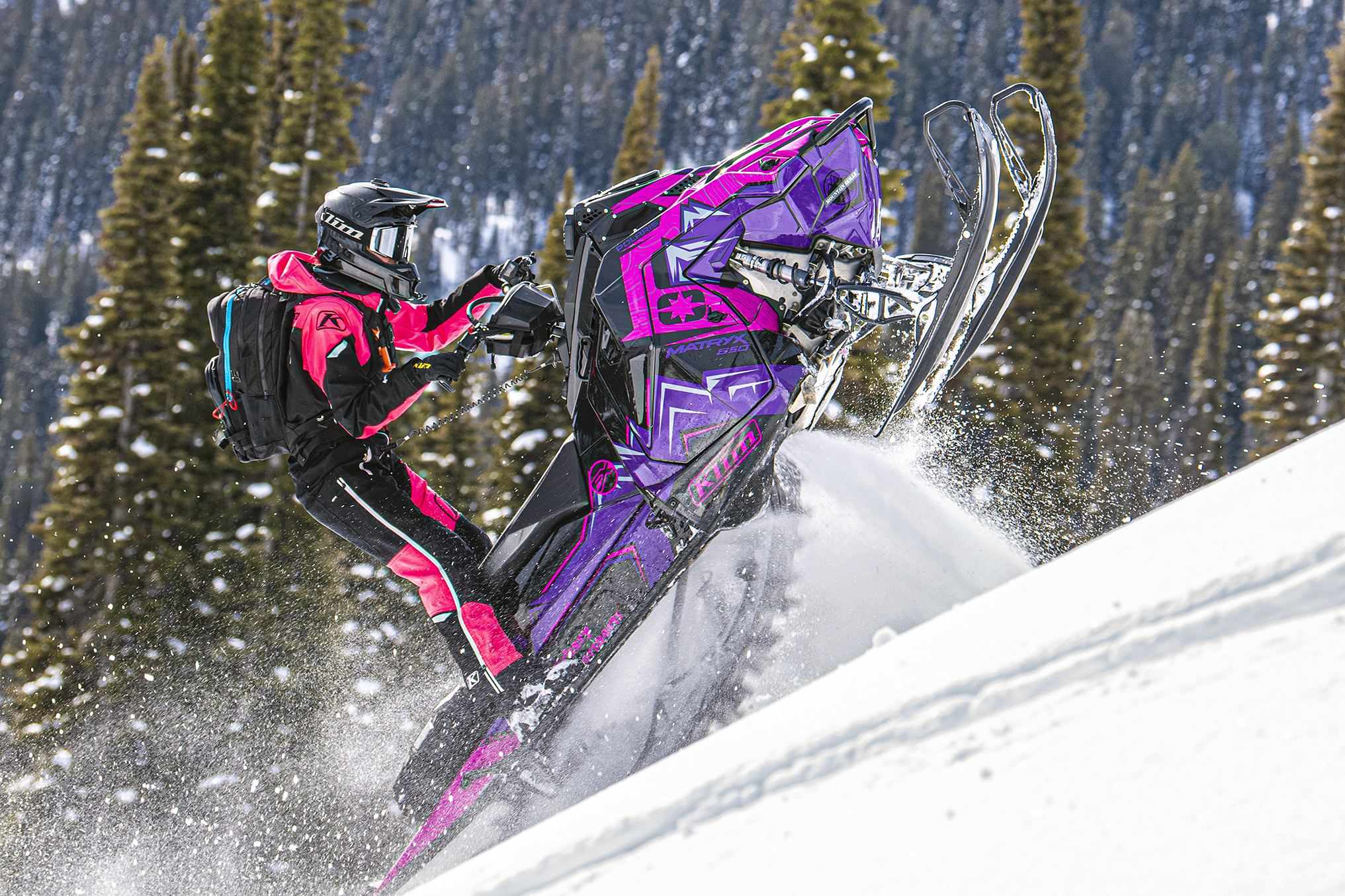 A Polaris Matryx Mountain snowmobile with a purple, pink, and black Teton custom vinyl wrap.
