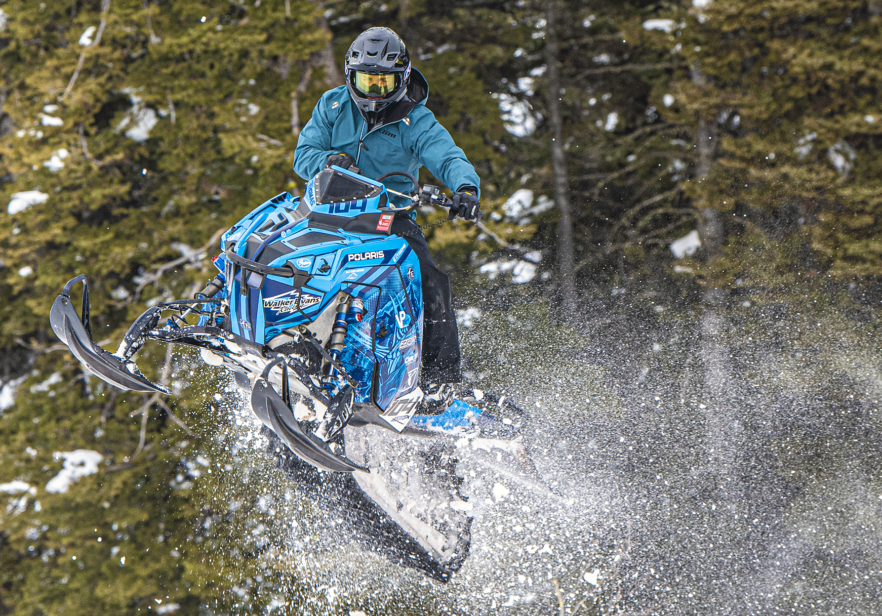 A Polaris Matryx Mountain snowmobile with a blue, black, and white Andy Thomas Attack custom vinyl wrap.