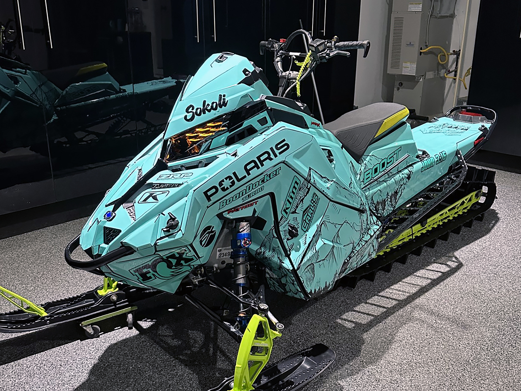 A Polaris Matryx Mountain snowmobile with a white, blue, and orange Andy Thomas Peaked custom vinyl wrap.
