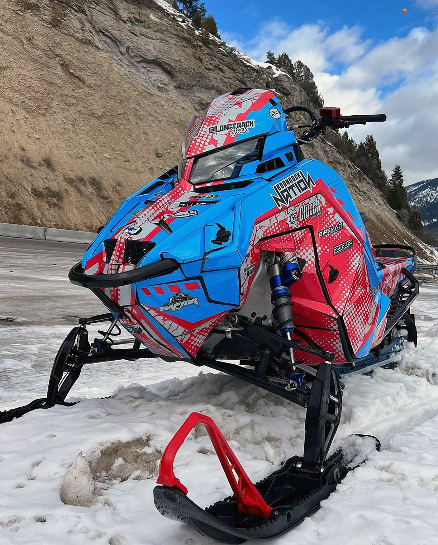 A Polaris Matryx Mountain snowmobile with a blue, gray, and red Vision custom vinyl wrap.