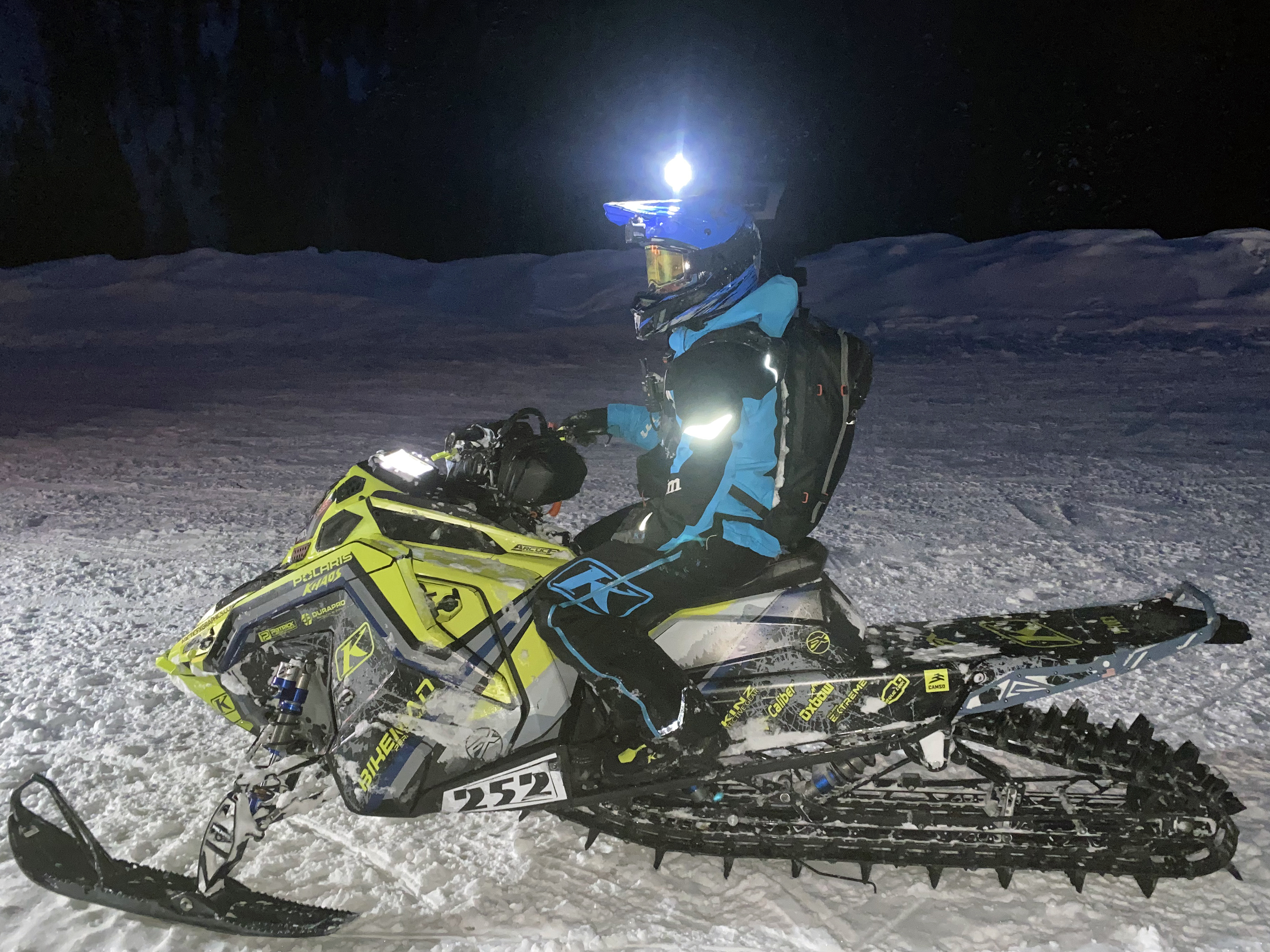 A Polaris Matryx Mountain snowmobile with a blue, gray, and lime squeeze Wilford Chilled custom vinyl wrap.