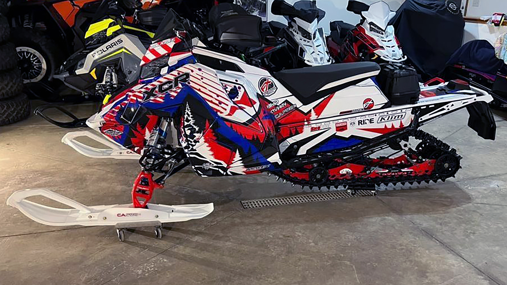 A Polaris Matryx Trail snowmobile with a red, white, and blue Leif Alvarsson Kingdom custom vinyl wrap.