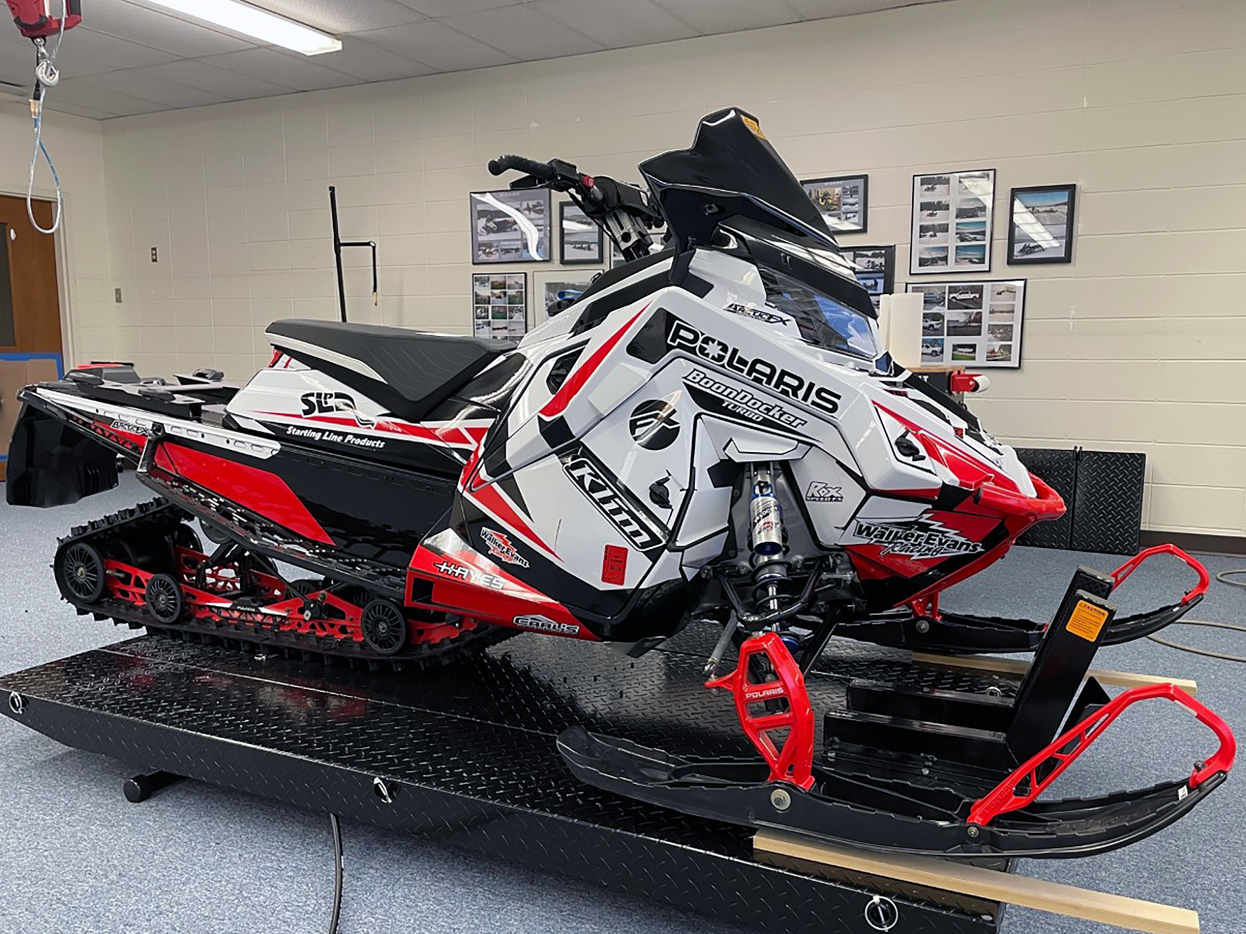 A Polaris Matryx Trail snowmobile with a white, red, and black Justin Thomas Velocity custom vinyl wrap.