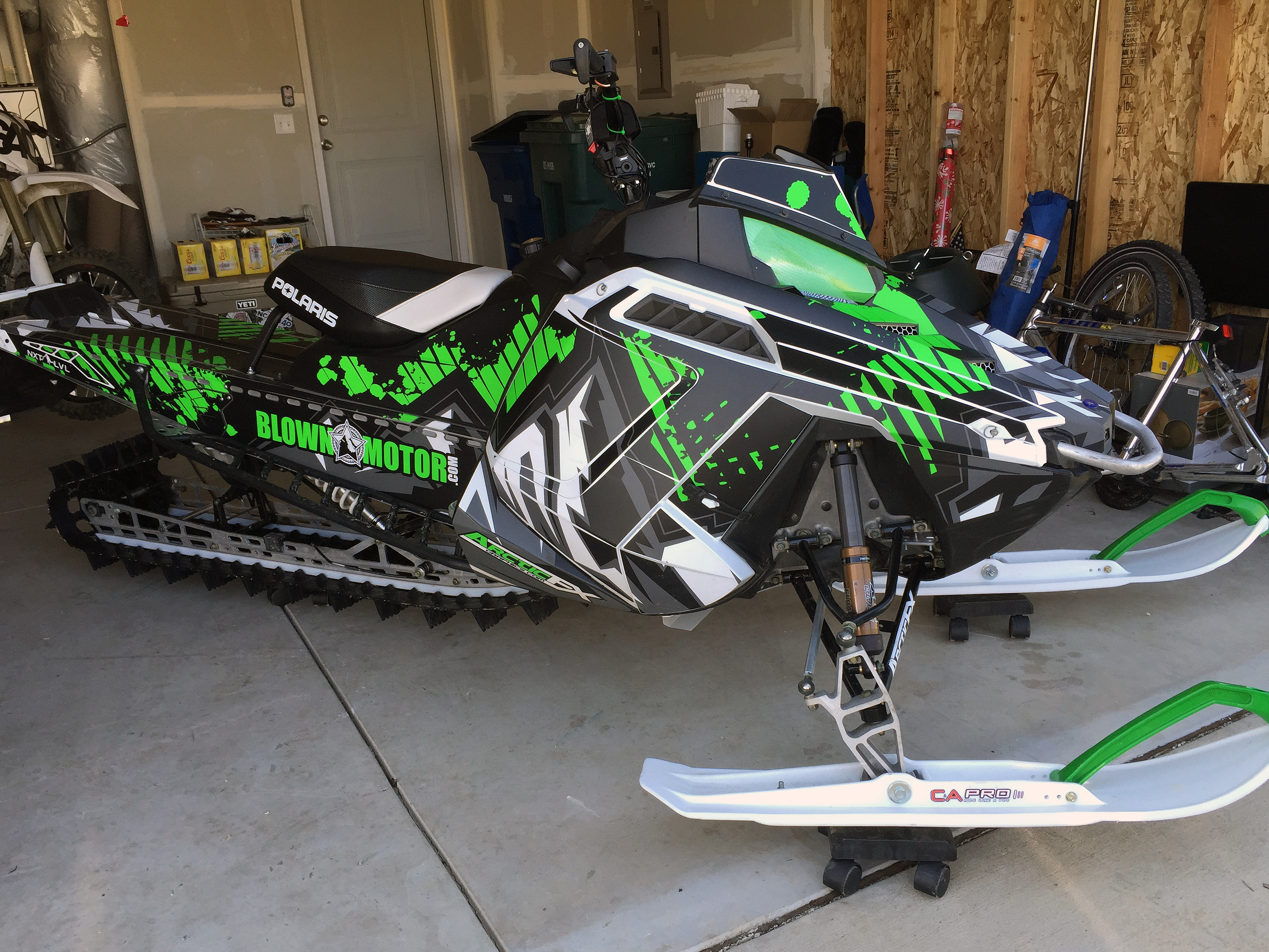 A Polaris Pro-Ride snowmobile with a lime, black, and white Altitude custom vinyl wrap.