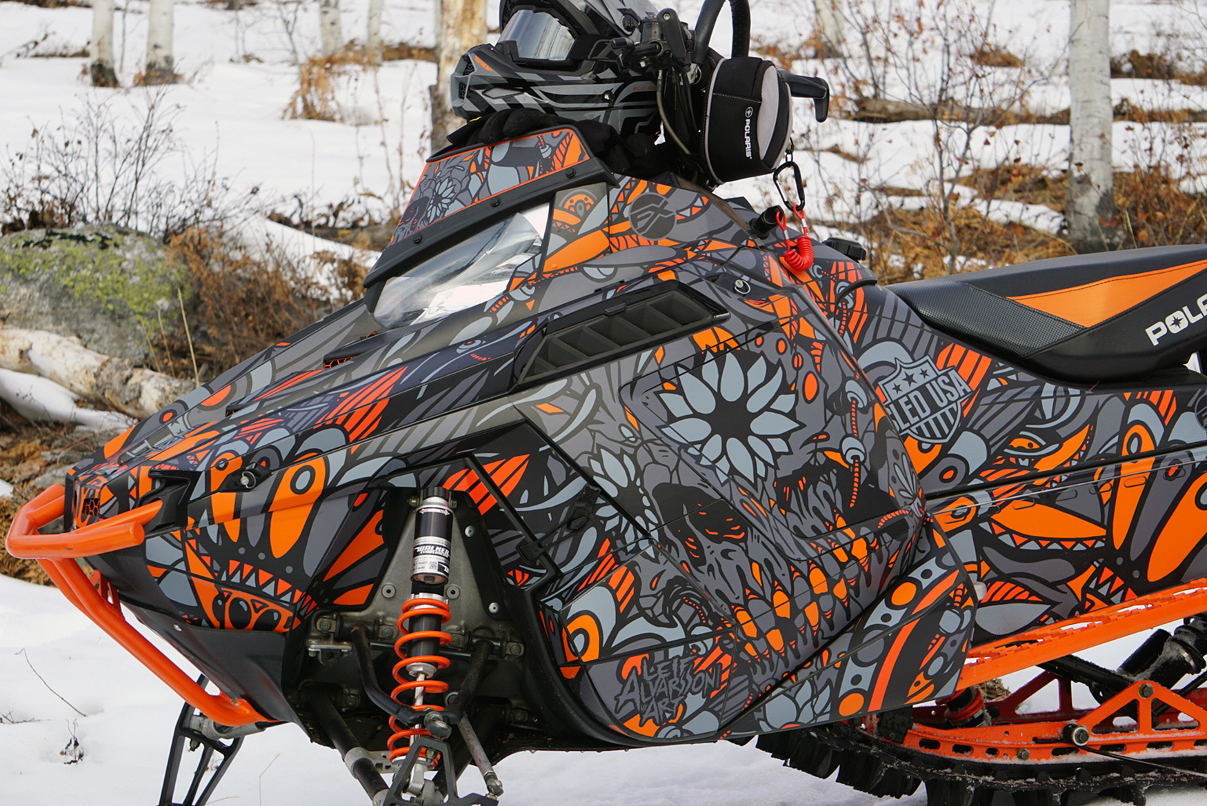 A Polaris Pro-Ride snowmobile with a orange, black, and gray Leif Alvarsson Calavera custom vinyl wrap.