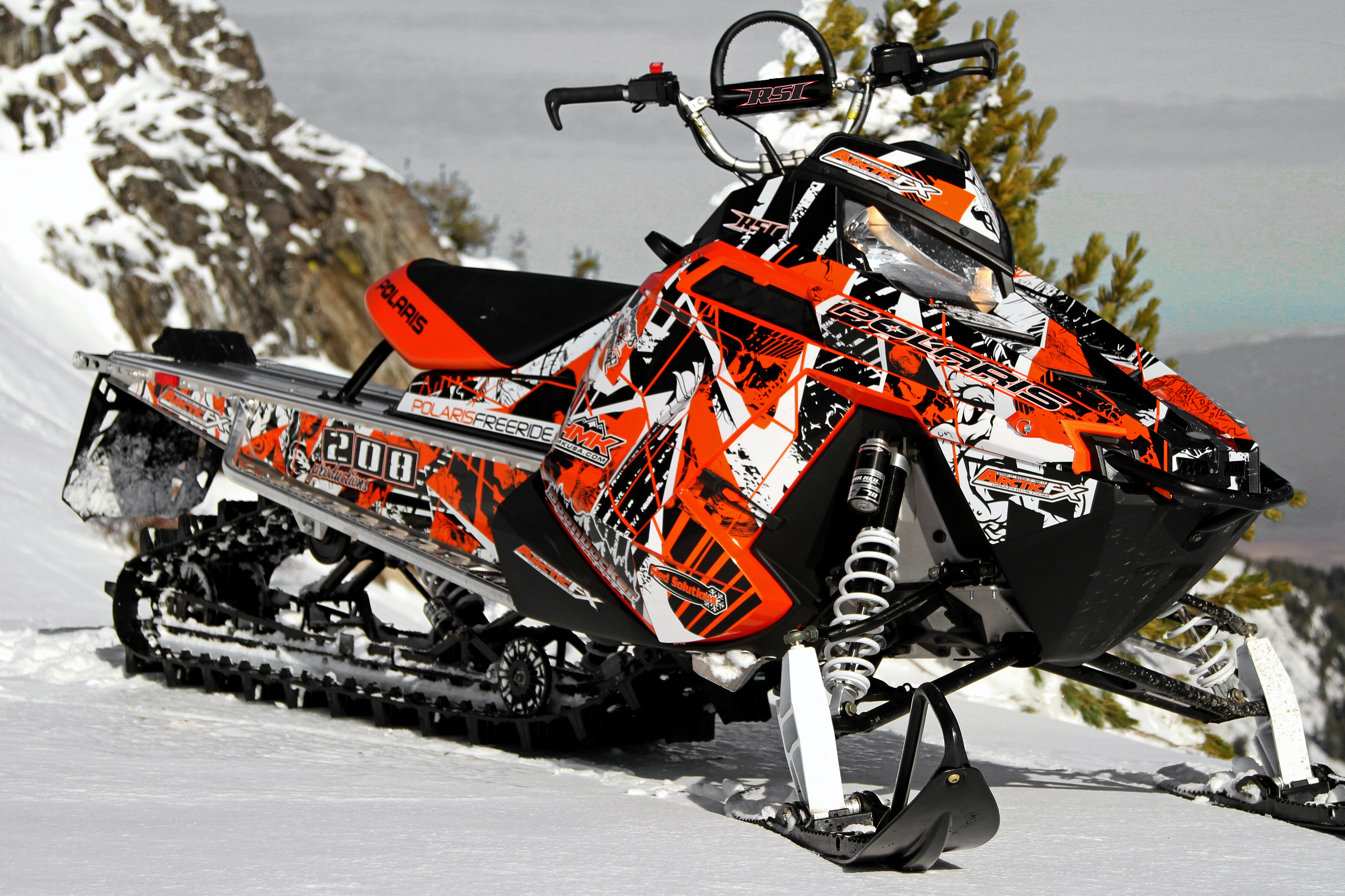 A Polaris Pro-Ride snowmobile with a orange, black, and white Broken Arrow custom vinyl wrap.