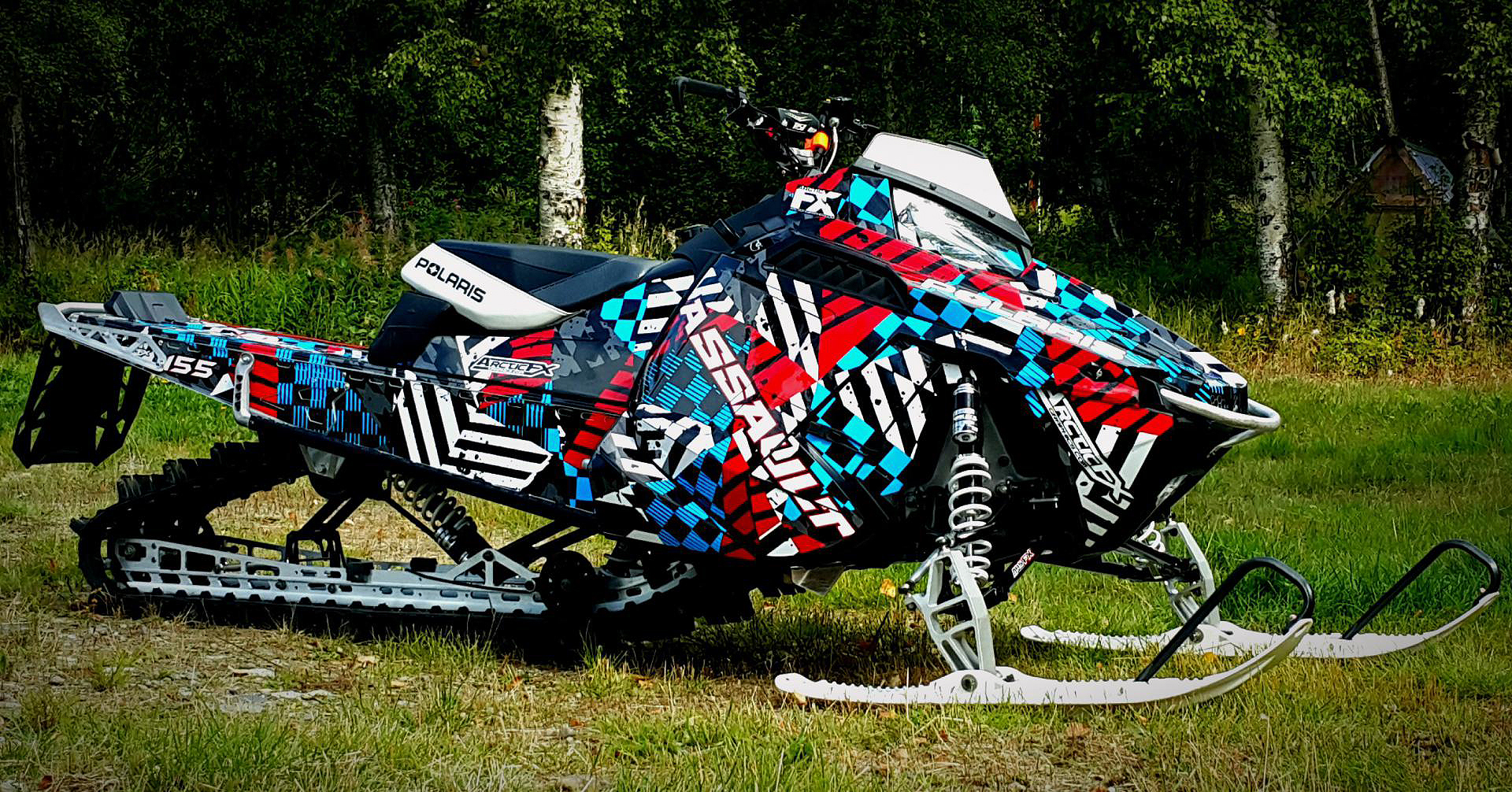 A Polaris Pro-Ride snowmobile with a red, white, and blue Cataclysm custom vinyl wrap.