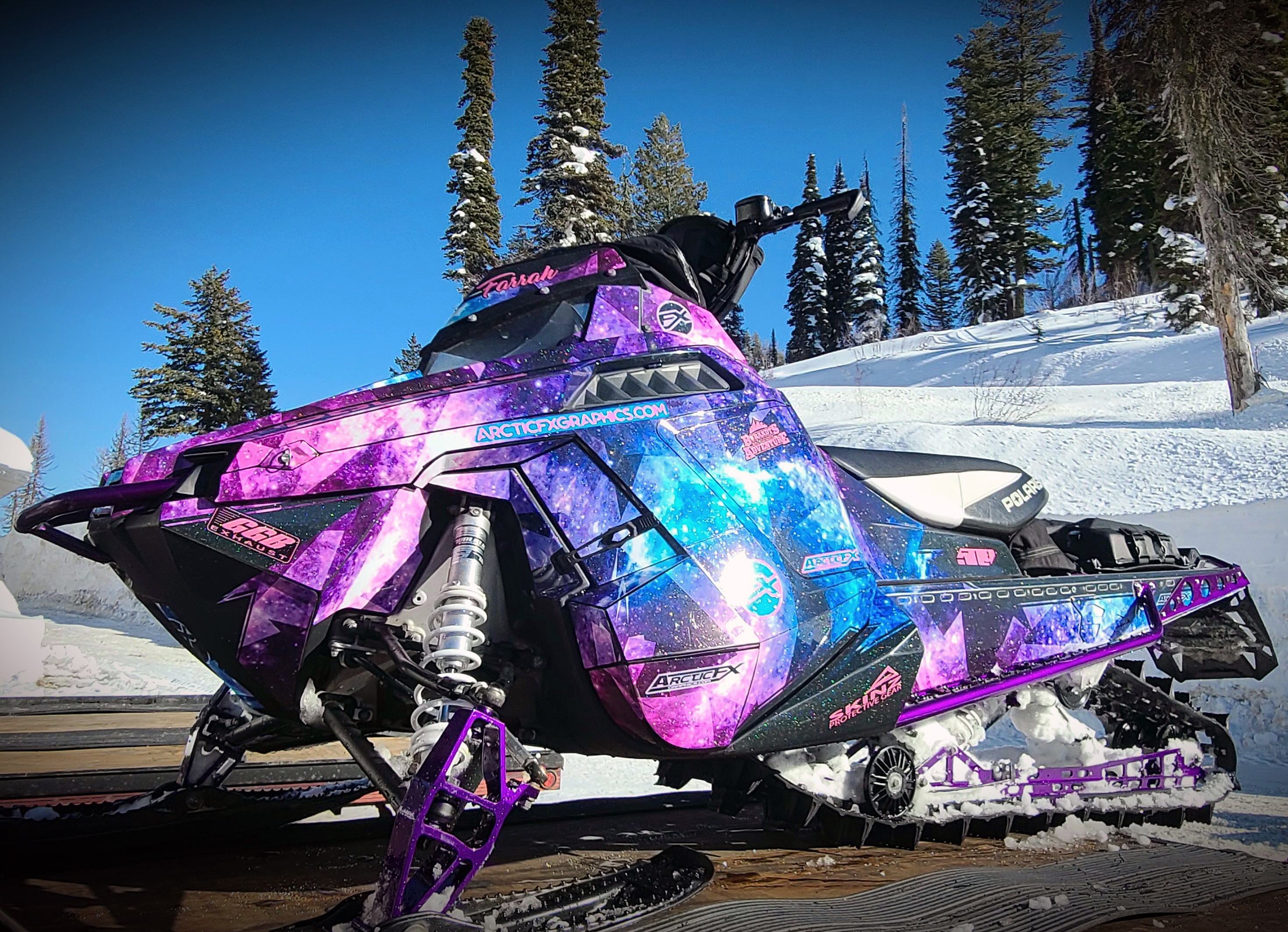 A Polaris Pro-Ride snowmobile with a blue and purple Cosmic Camo custom vinyl wrap.