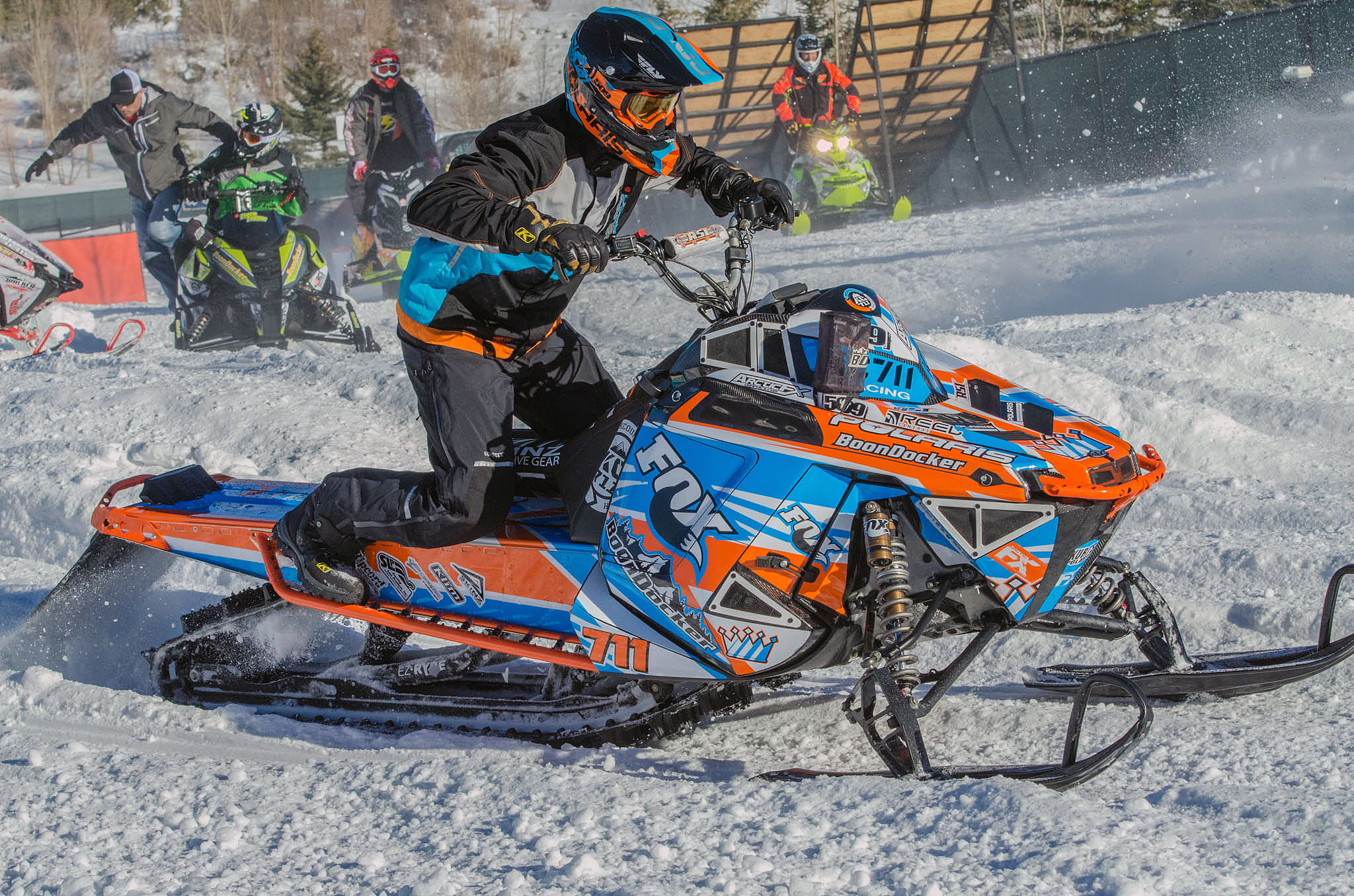 A Polaris Pro-Ride snowmobile with a orange, white, and blue Curtis Mountain King custom vinyl wrap.