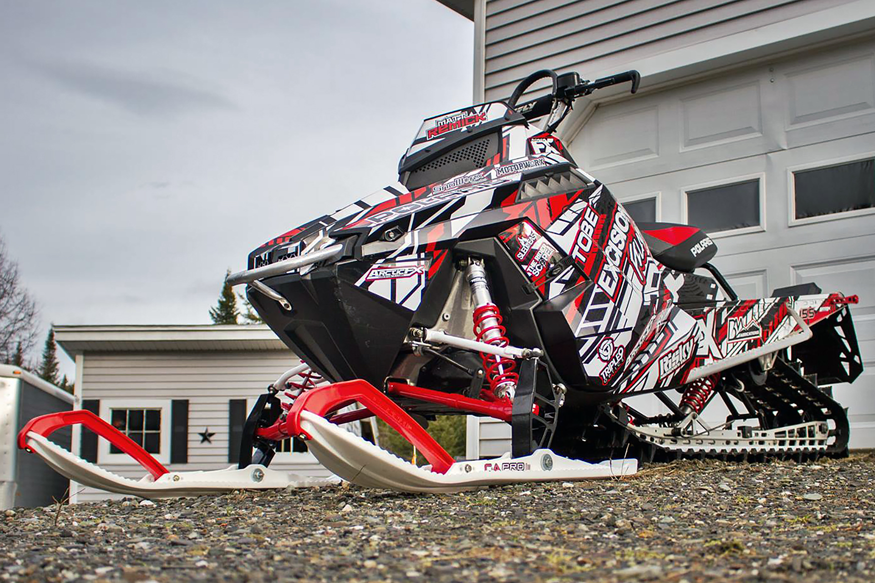 A Polaris Pro-Ride snowmobile with a red, white, and black Evasion custom vinyl wrap.