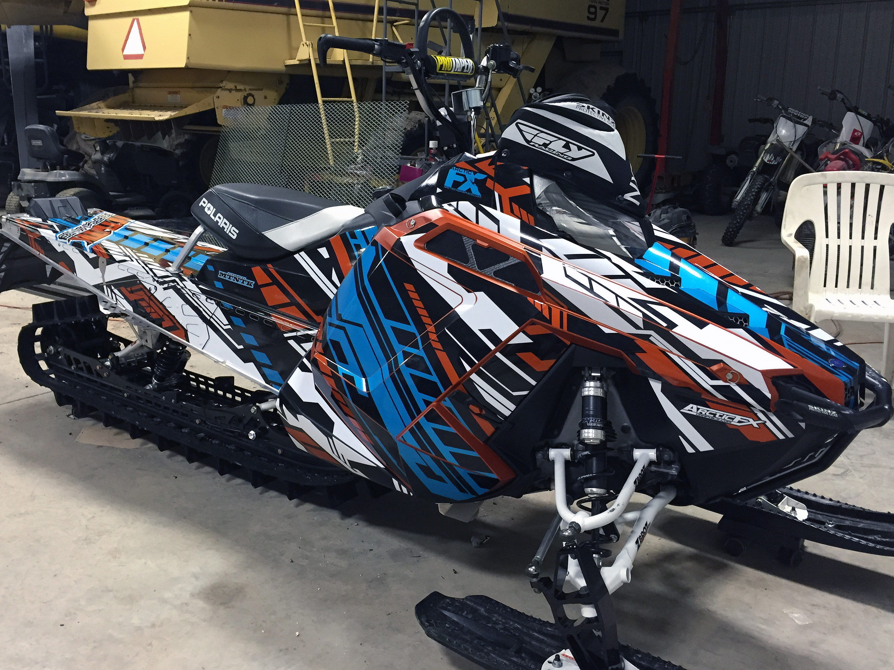 A Polaris Pro-Ride snowmobile with a red, white, and blue Evasion custom vinyl wrap.