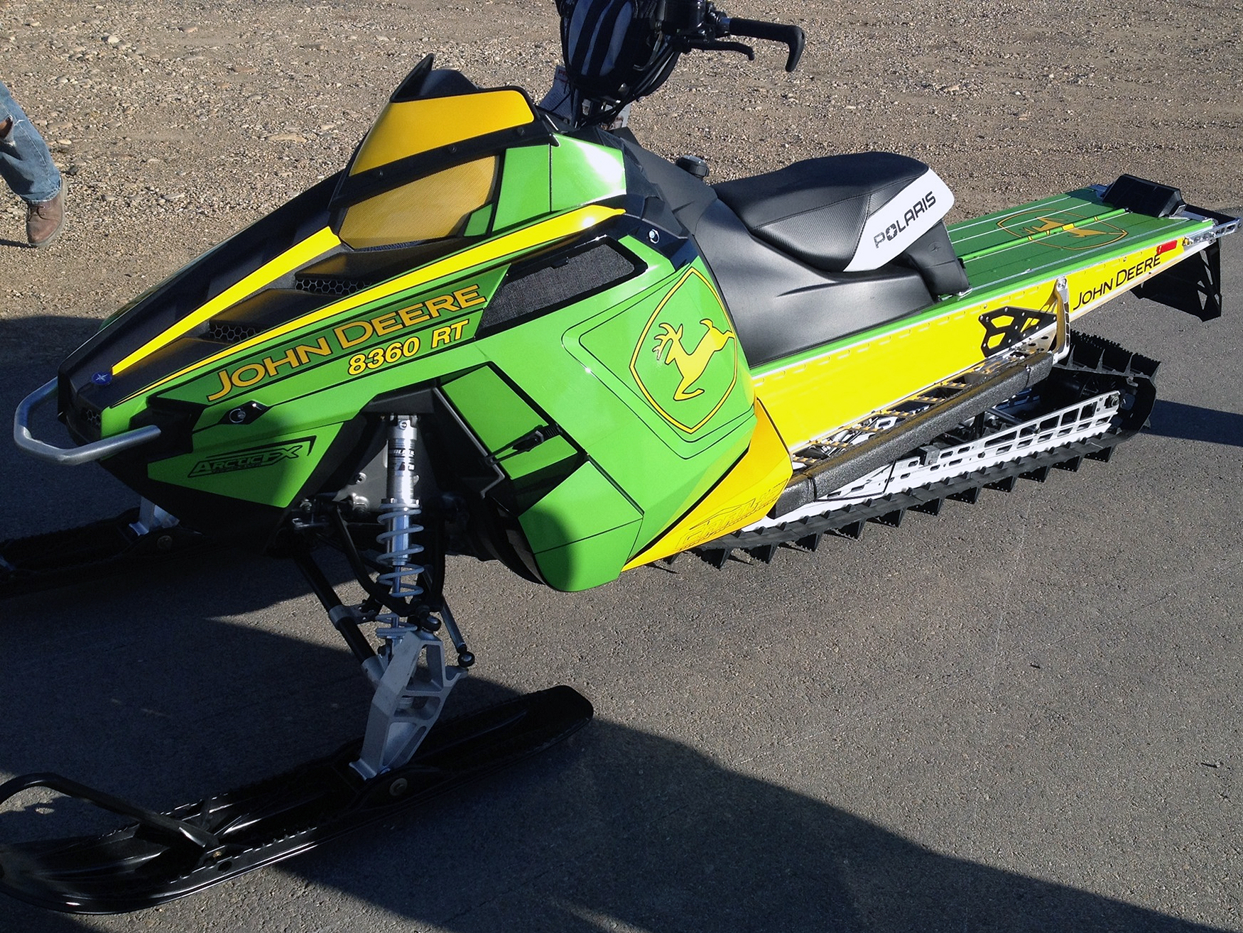 A Polaris Pro-Ride snowmobile with a green, yellow, and black John Deere custom vinyl wrap.