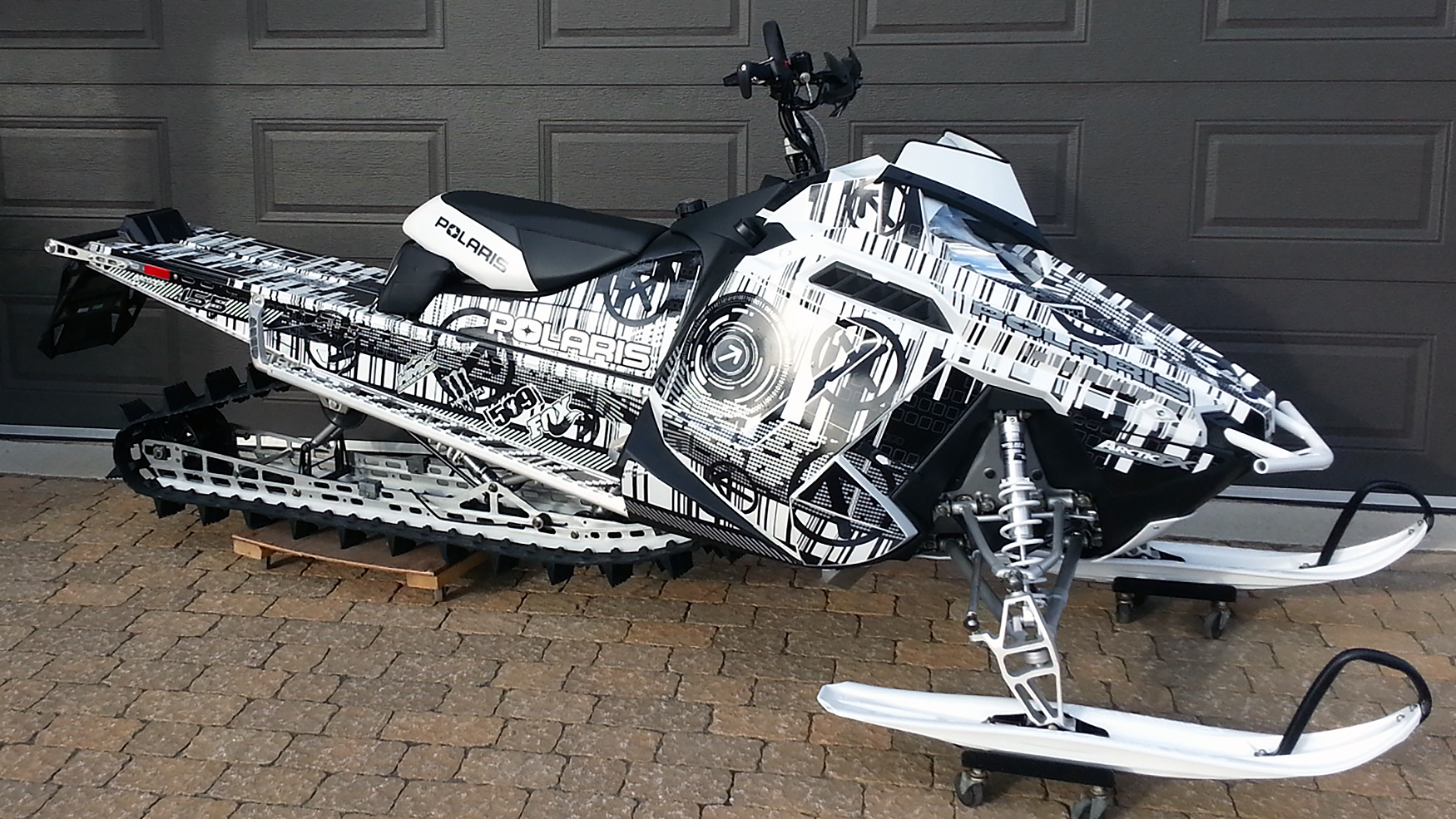 A Polaris Pro-Ride snowmobile with a black and white Mainframe custom vinyl wrap.