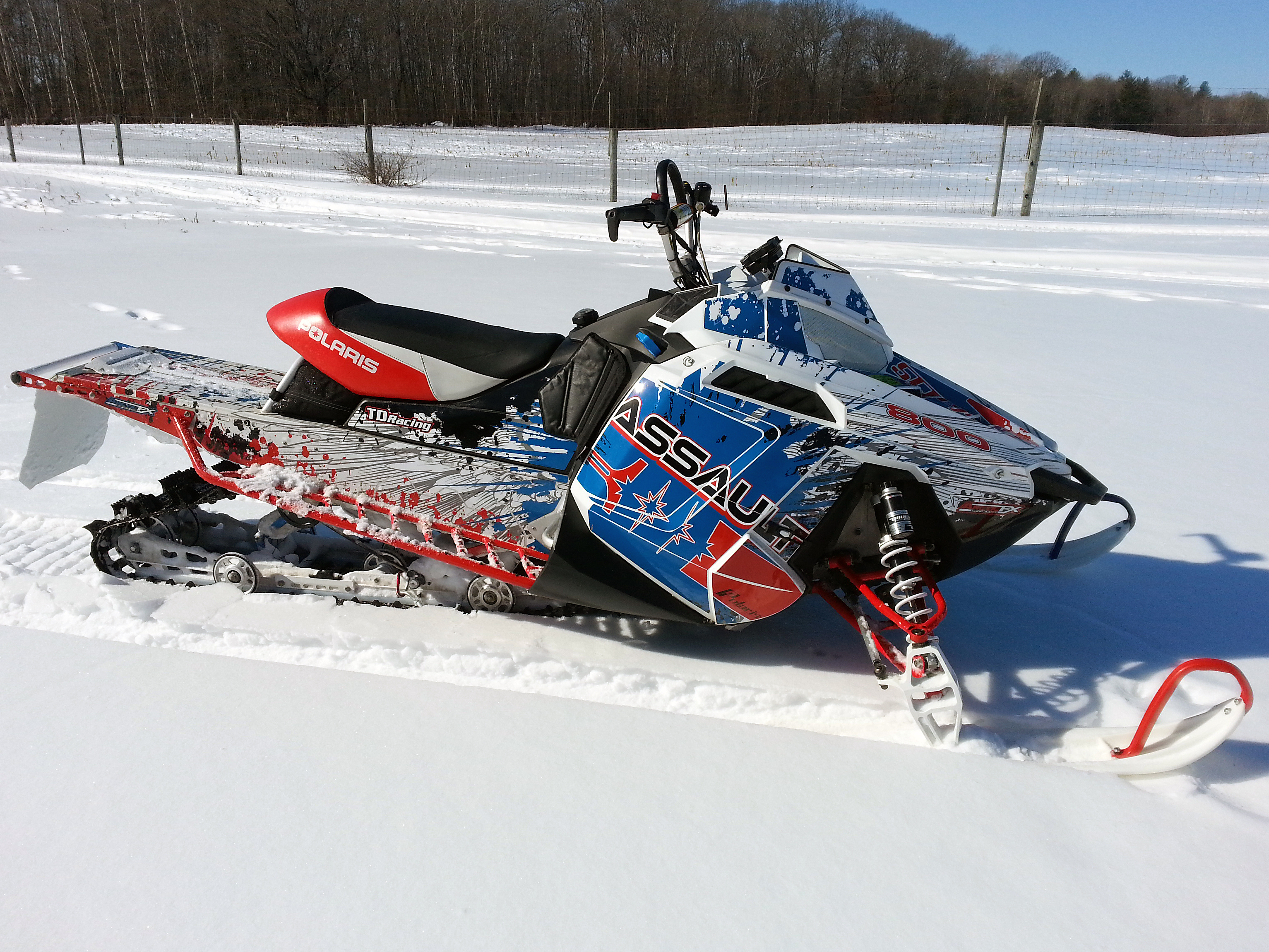A Polaris Pro-Ride snowmobile with a red, white, and blue Retrobution custom vinyl wrap.